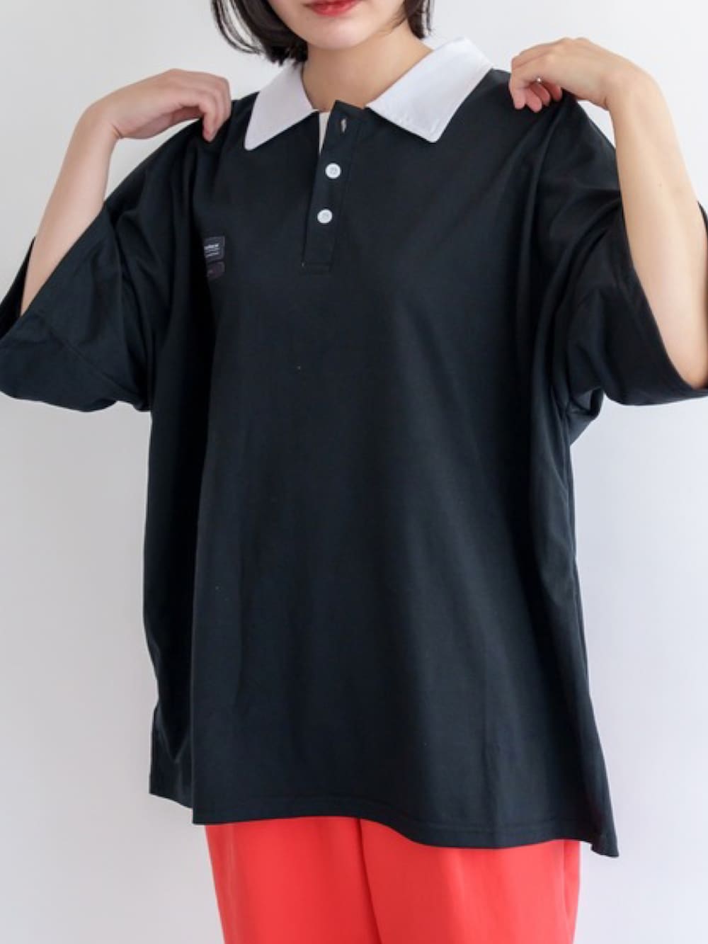 ブラック系のポロシャツを着用したレディースの夏コーディネートの4枚目の写真