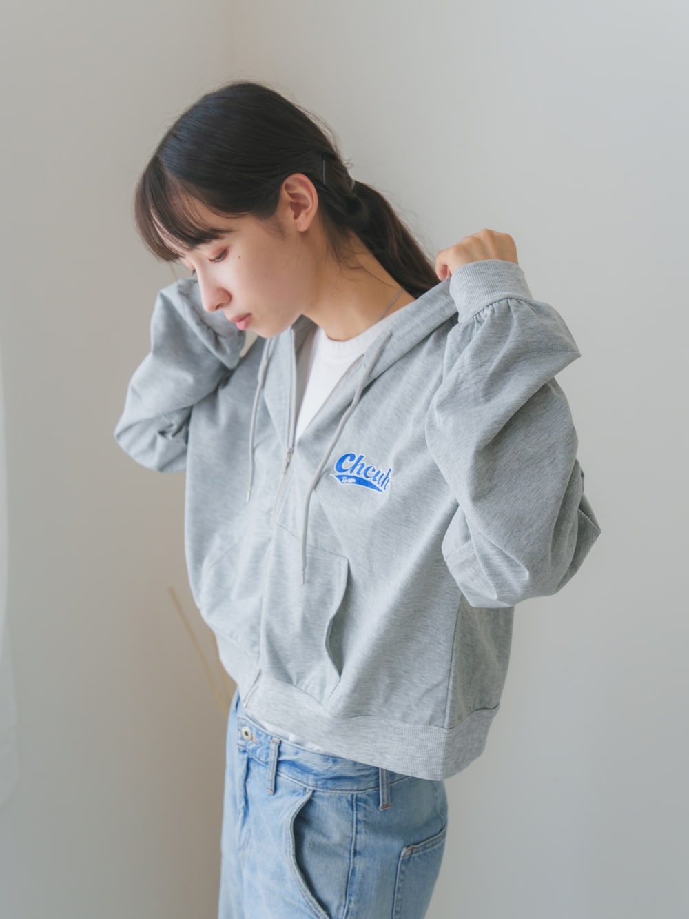 グレー系のパーカーを着用したレディースの秋コーディネートの2枚目の写真