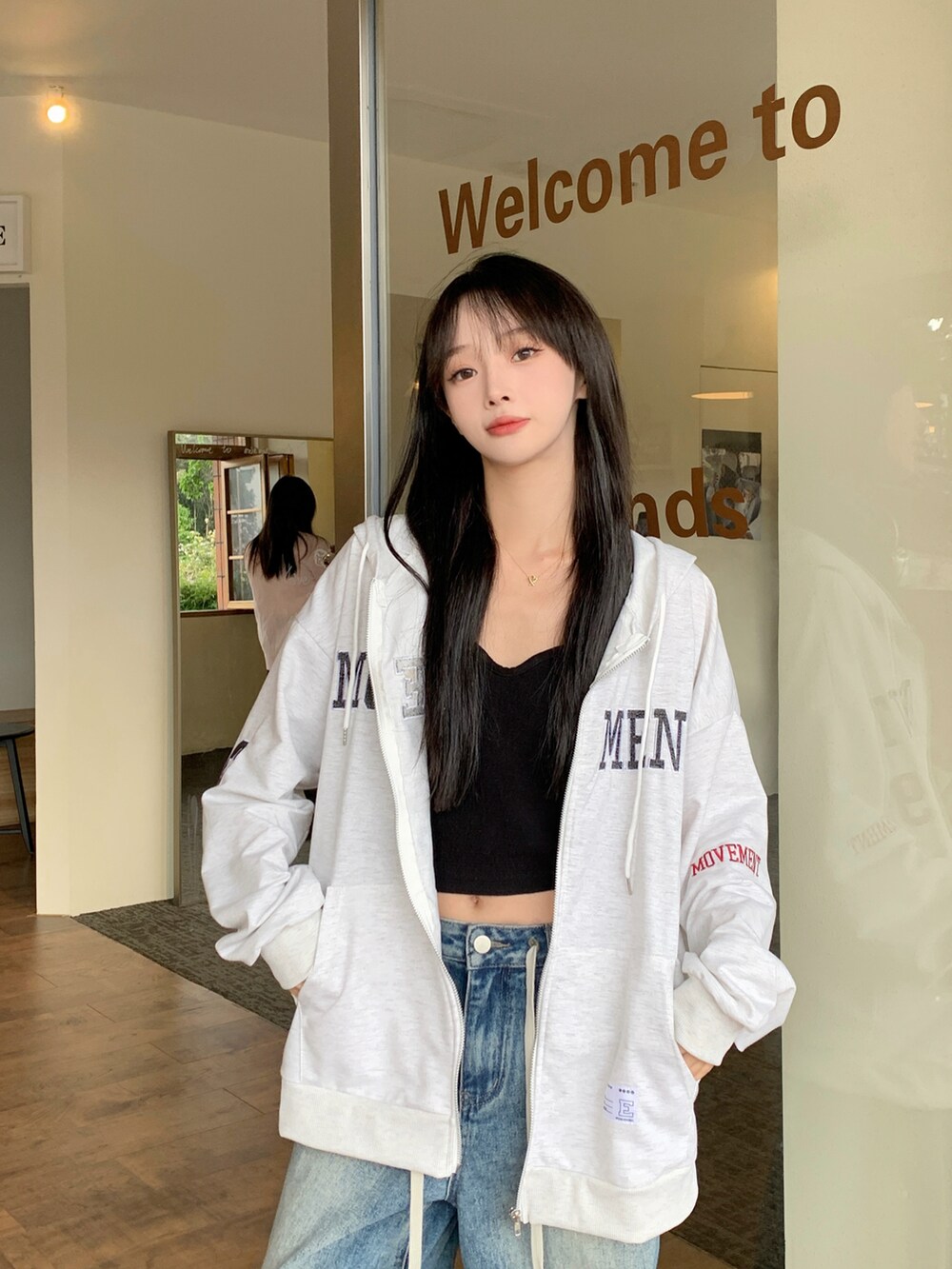 グレー系のパーカーを着用したレディースの春コーディネートの3枚目の写真