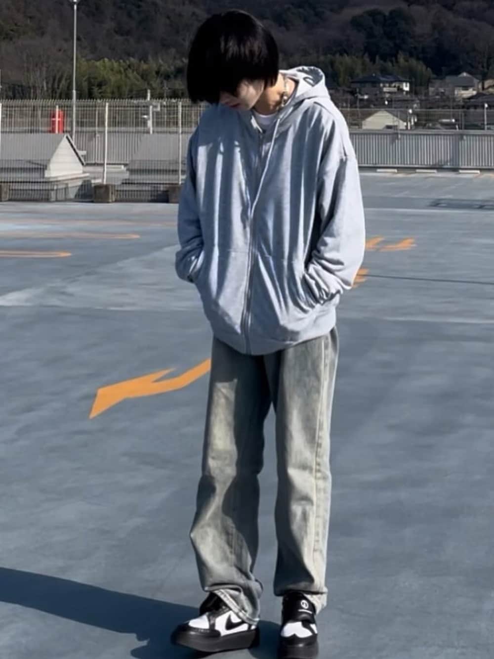 グレー系のパーカーを着用したレディースの春コーディネートの2枚目の写真