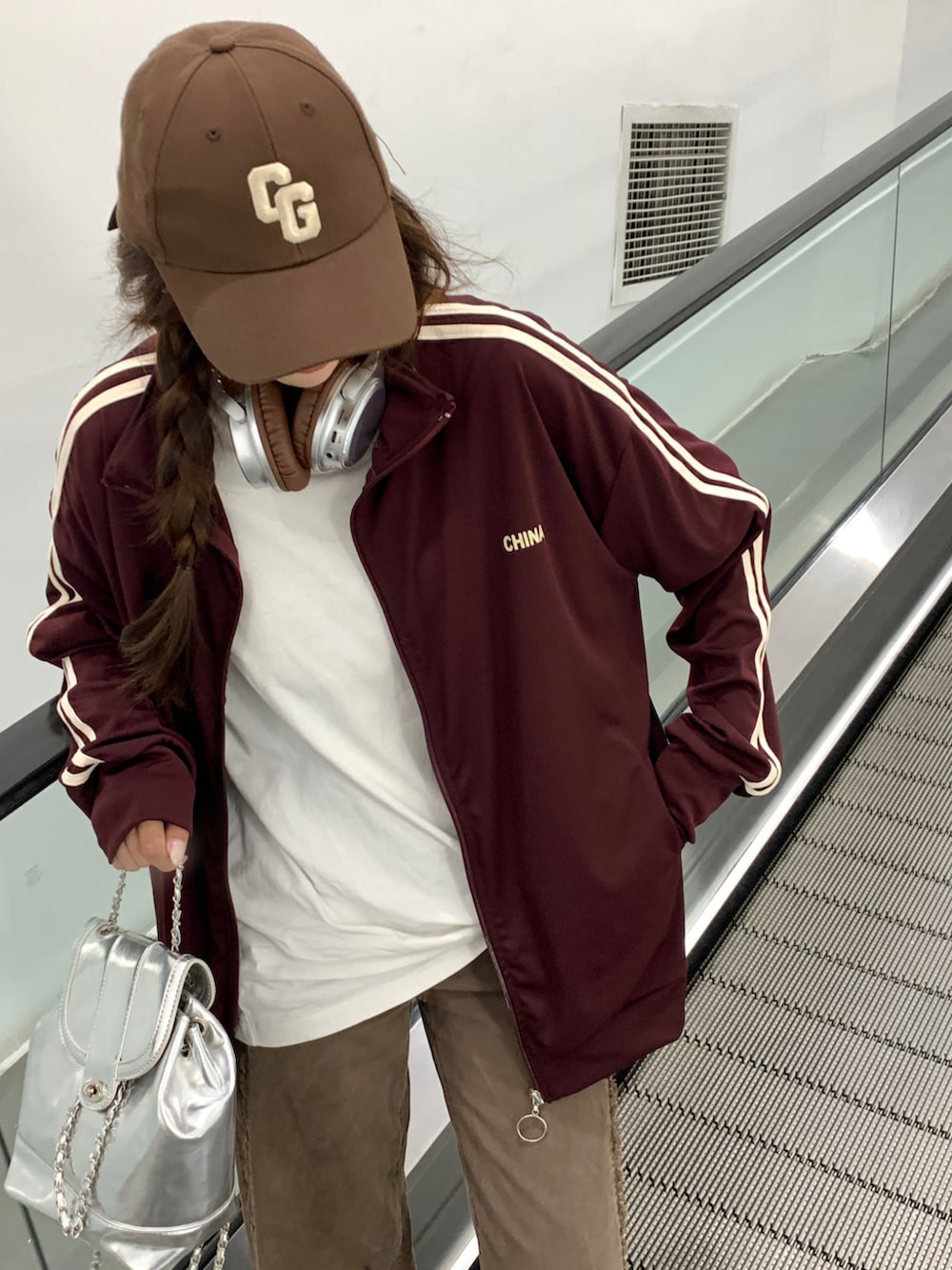 レッド系のジャージを着用したレディースの秋コーディネートの4枚目の写真