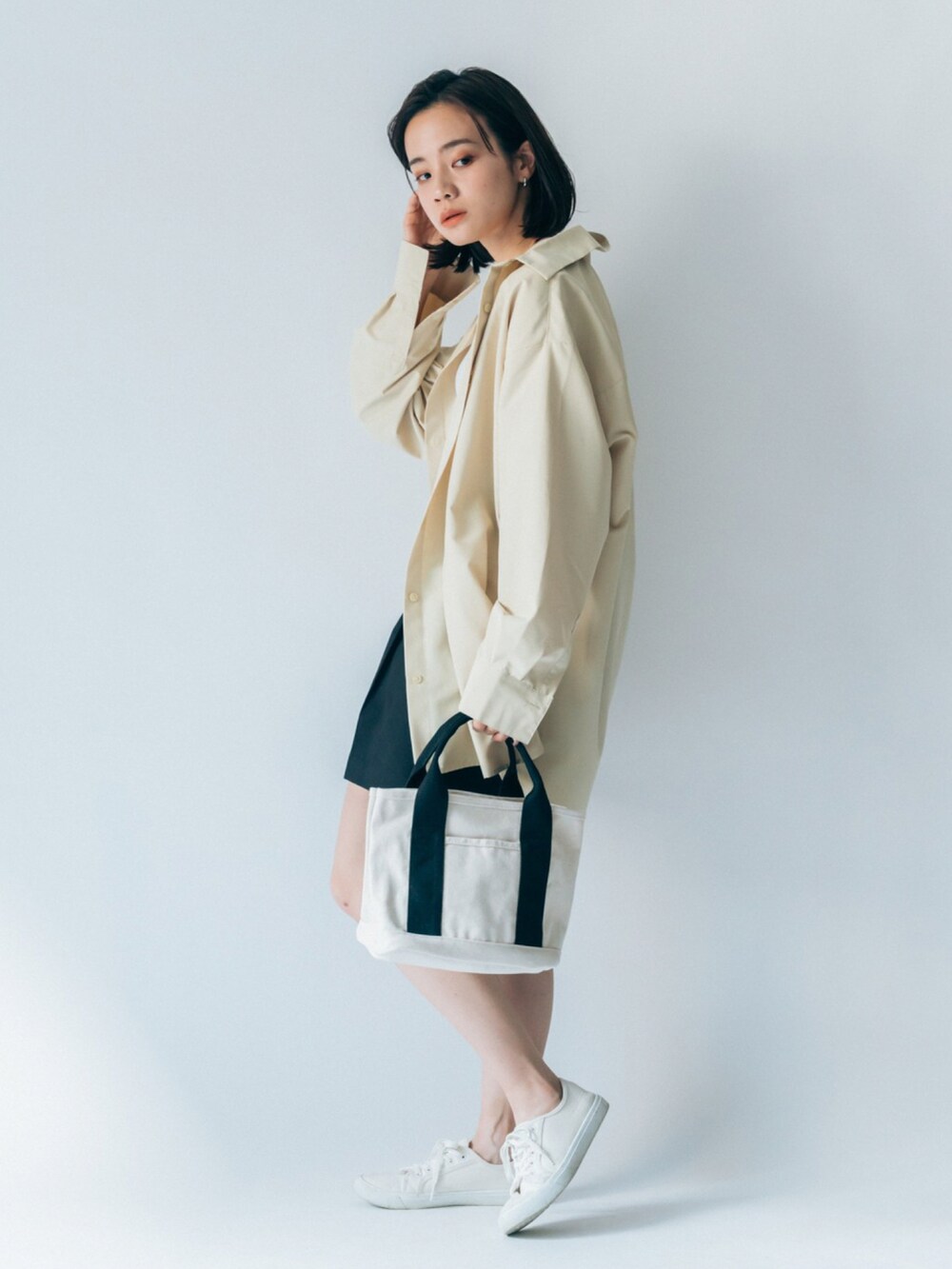 ベージュ系のトートバッグを着用したレディースの冬コーディネートの2枚目の写真