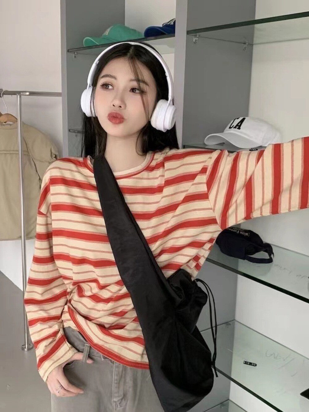 オレンジ系のTシャツ/カットソーを着用したレディースの秋コーディネートの2枚目の写真