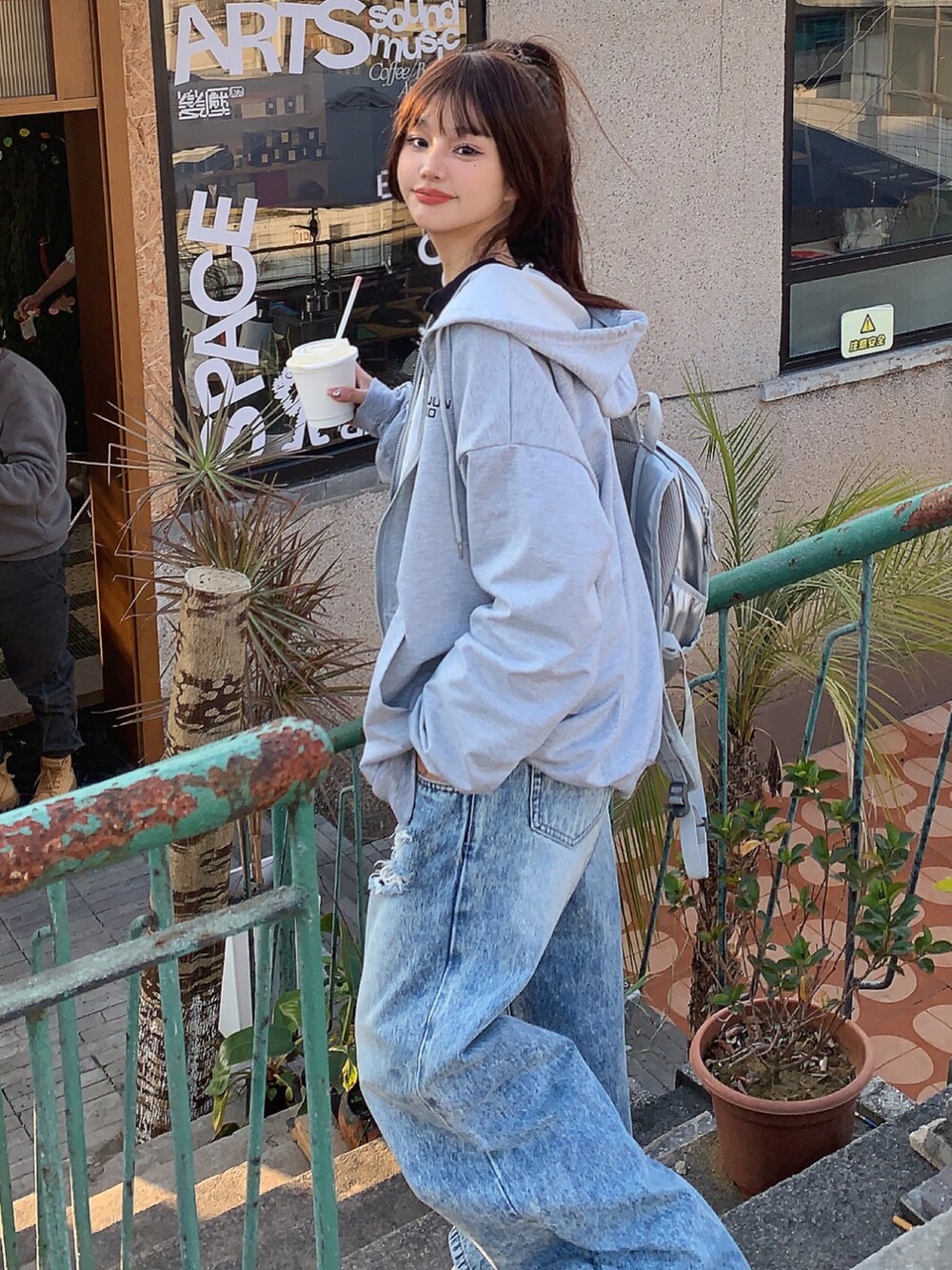 グレー系のパーカーを着用したレディースの冬コーディネートの3枚目の写真