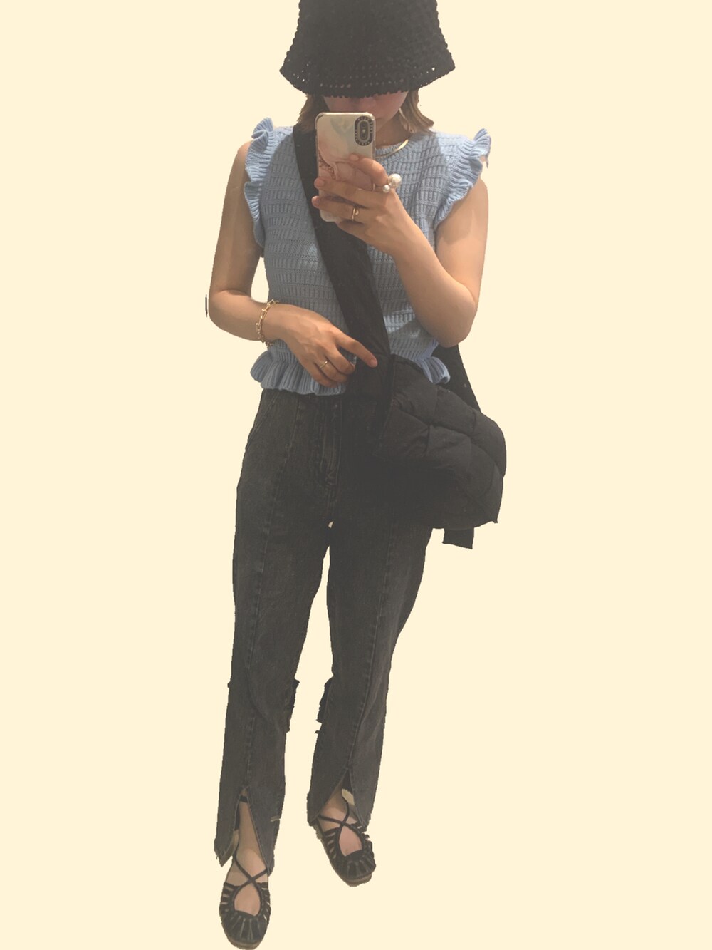 ブルー系のニット/セーター、ブラック系のショルダーバッグ、ブラック系のデニムパンツを着用したレディースの夏コーディネートの2枚目の写真