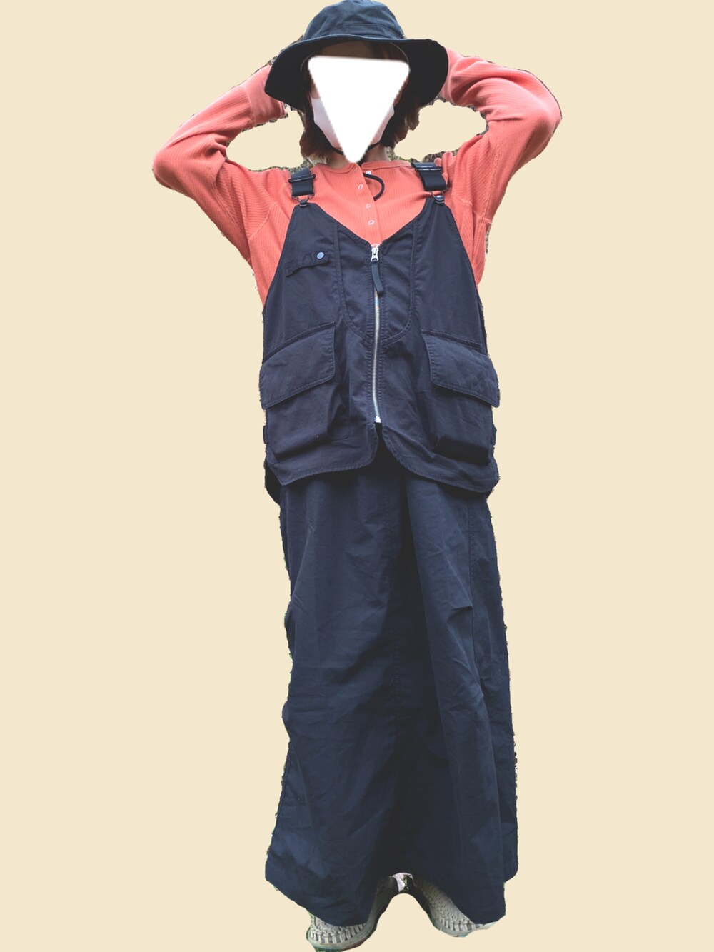 ブラック系のベスト、オレンジ系のTシャツ/カットソー、ブラック系のジャンパースカートを着用したレディースの春コーディネートの2枚目の写真