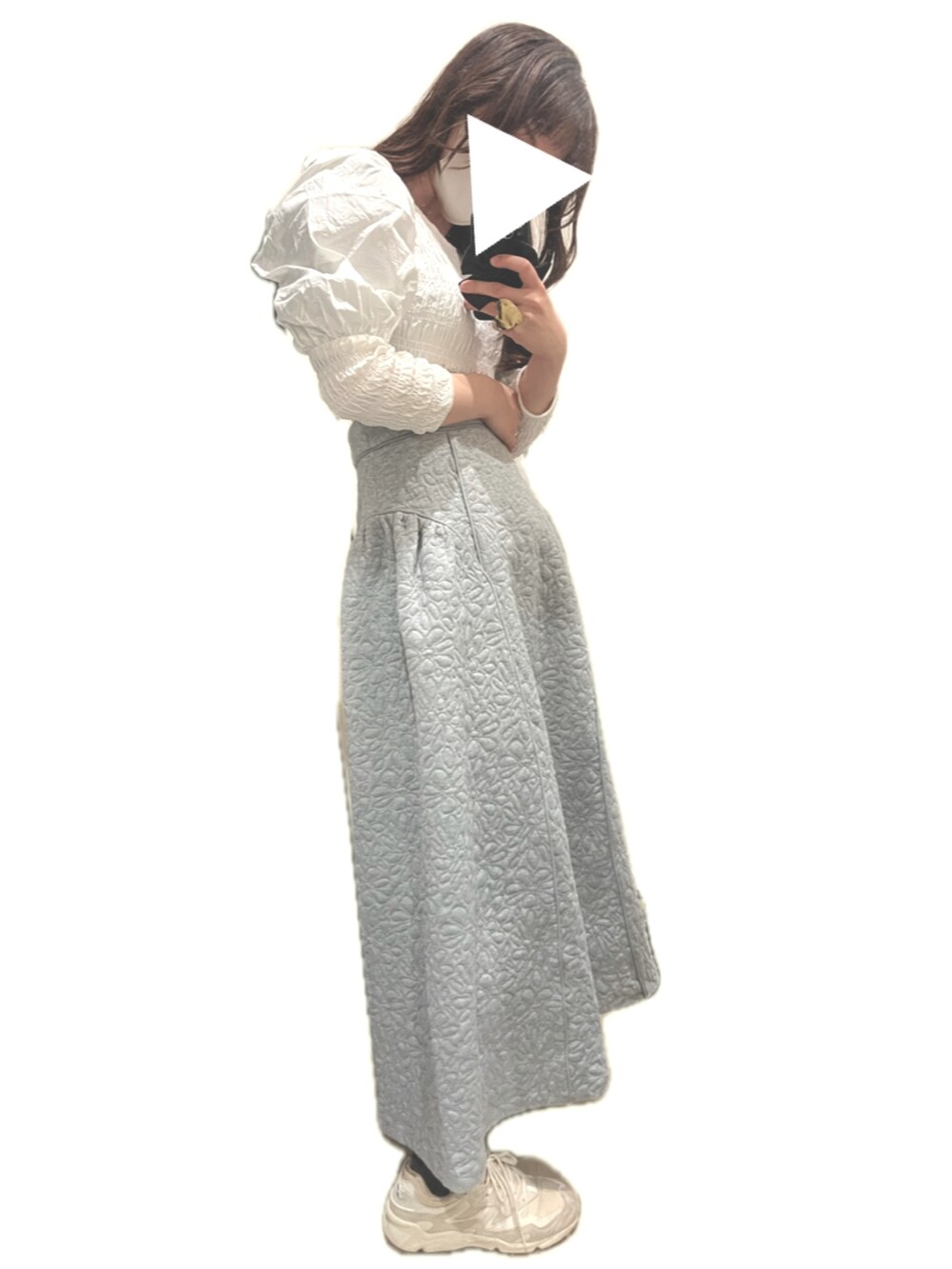 グリーン系のハンドバッグ、ベージュ系のスニーカー、グレー系のスカートを着用したレディースの冬コーディネートの2枚目の写真