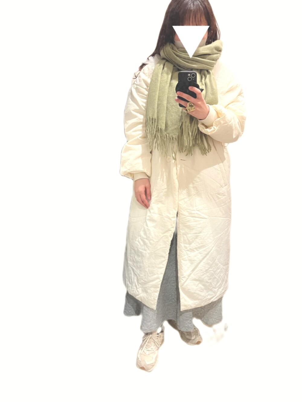 グリーン系のハンドバッグ、ベージュ系のスニーカー、グレー系のスカートを着用したレディースの冬コーディネートの3枚目の写真