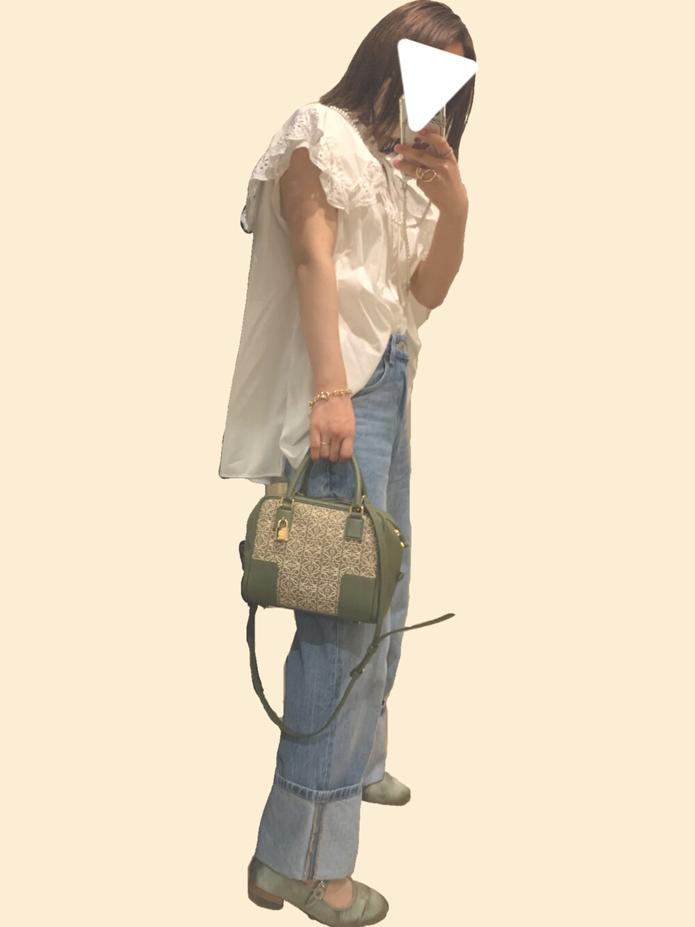 ブルー系のデニムパンツ、グリーン系のハンドバッグ、グリーン系のパンプスを着用したレディースの夏コーディネートの2枚目の写真