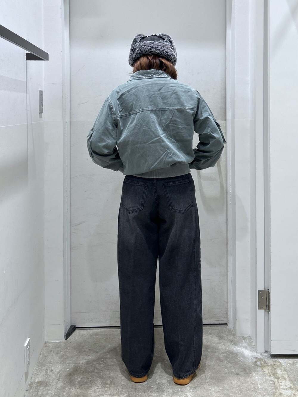 グリーン系のブルゾン、ブラック系のデニムパンツを着用したレディースの秋コーディネートの2枚目の写真