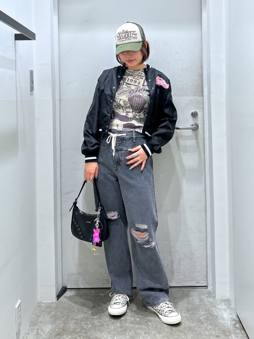 ブラック系のスタジャン、ブルー系のデニムパンツを着用したレディースの秋コーディネートの2枚目の写真