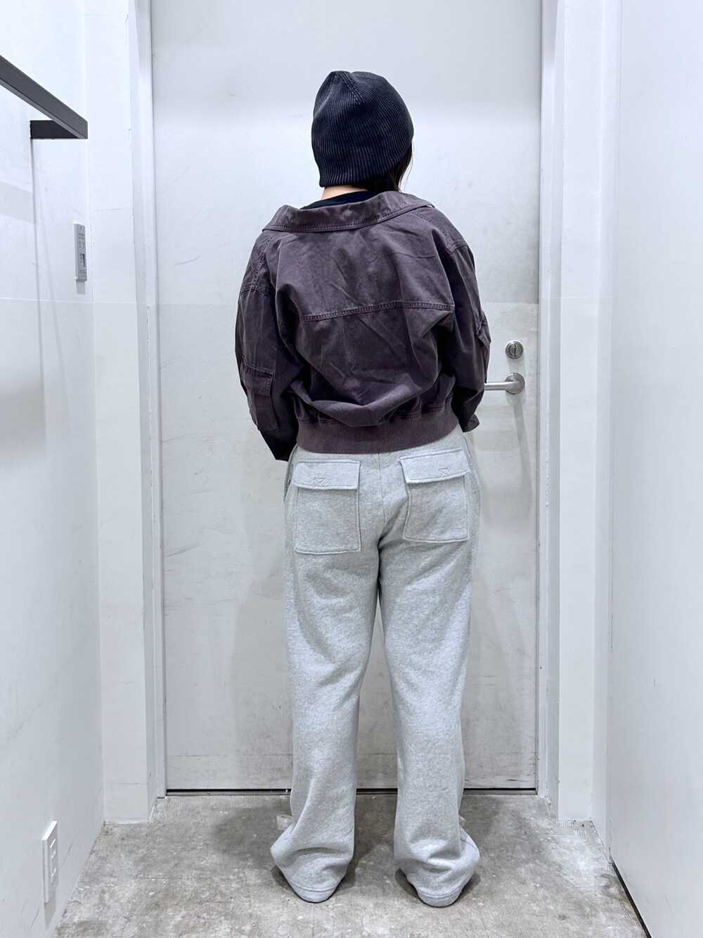 グリーン系のブルゾン、ブラック系のスウェットパンツを着用したレディースの秋コーディネートの2枚目の写真