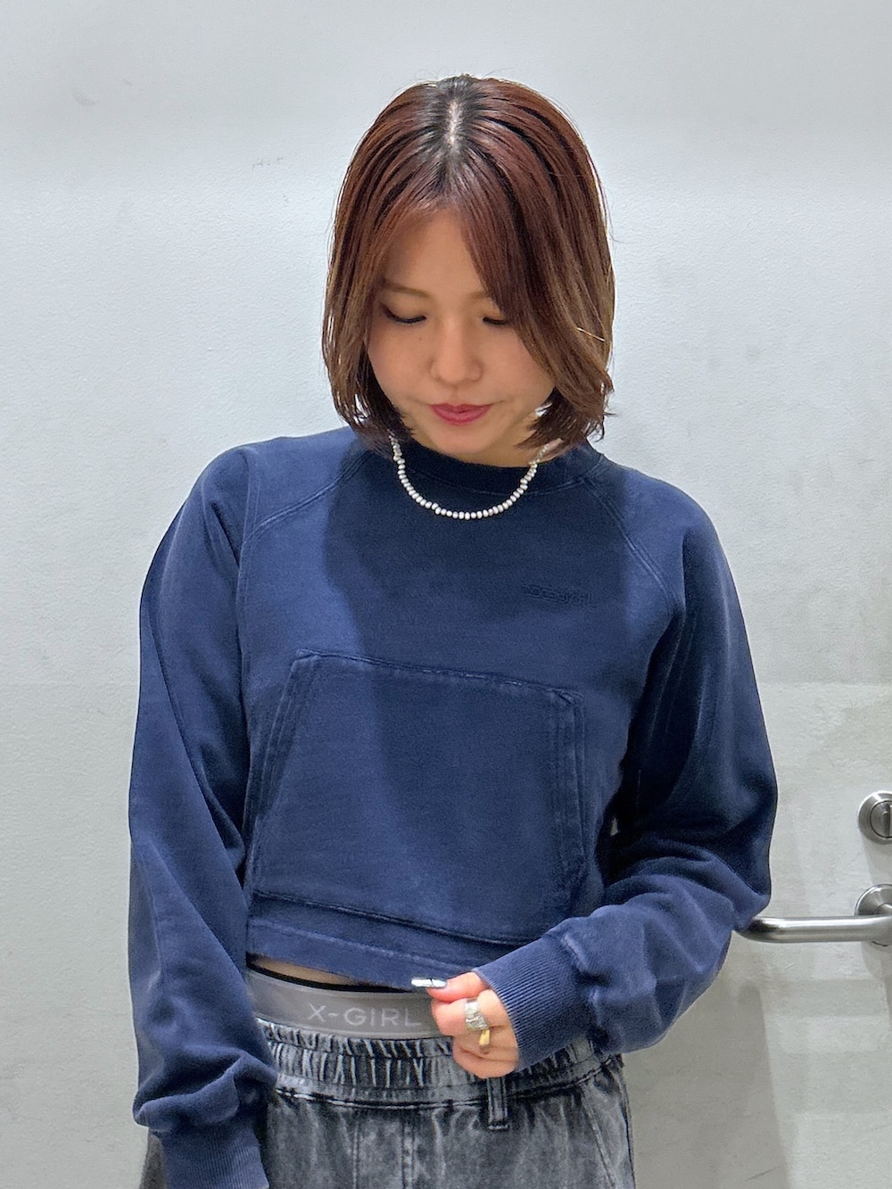 グリーン系のスウェット、ベージュ系のカーゴパンツ、ブラック系のハンドバッグを着用したレディースの秋コーディネートの2枚目の写真