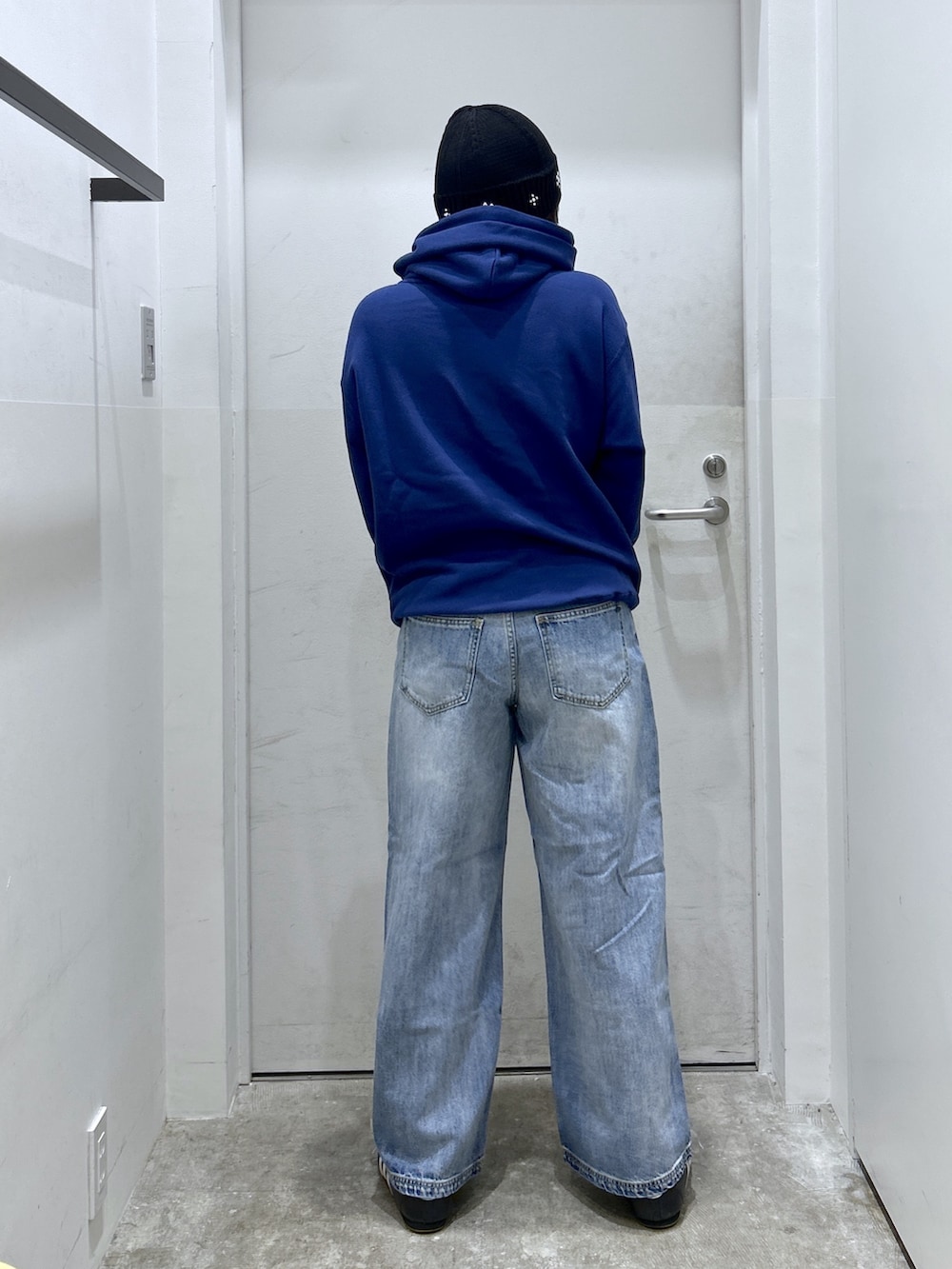 ブルー系のパーカー、ブルー系のデニムパンツを着用したレディースの秋コーディネートの2枚目の写真