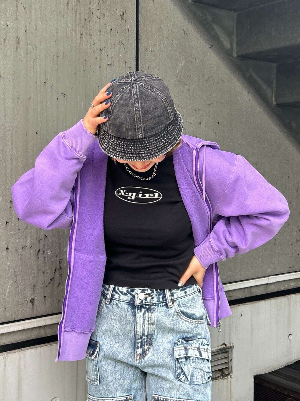 パープル系のパーカー、ブルー系のデニムパンツを着用したレディースの春コーディネートの2枚目の写真