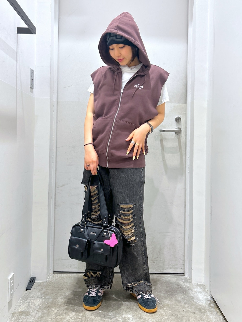 ブラウン系のベスト、ブラック系のデニムパンツを着用したレディースの夏コーディネートの2枚目の写真