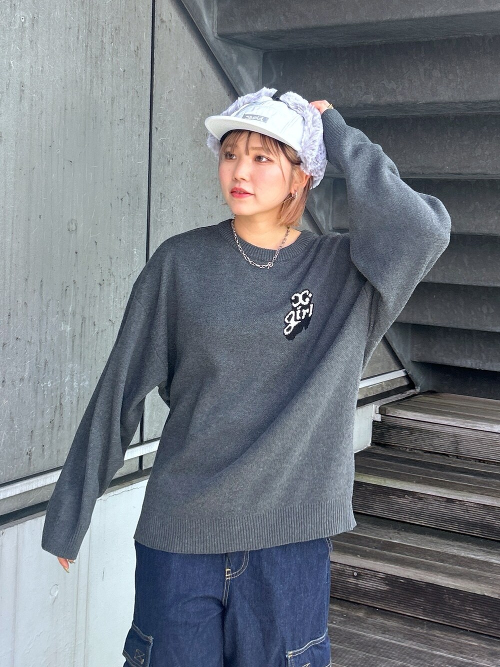 グレー系のニット/セーター、ブルー系のデニムパンツを着用したレディースの秋コーディネートの2枚目の写真