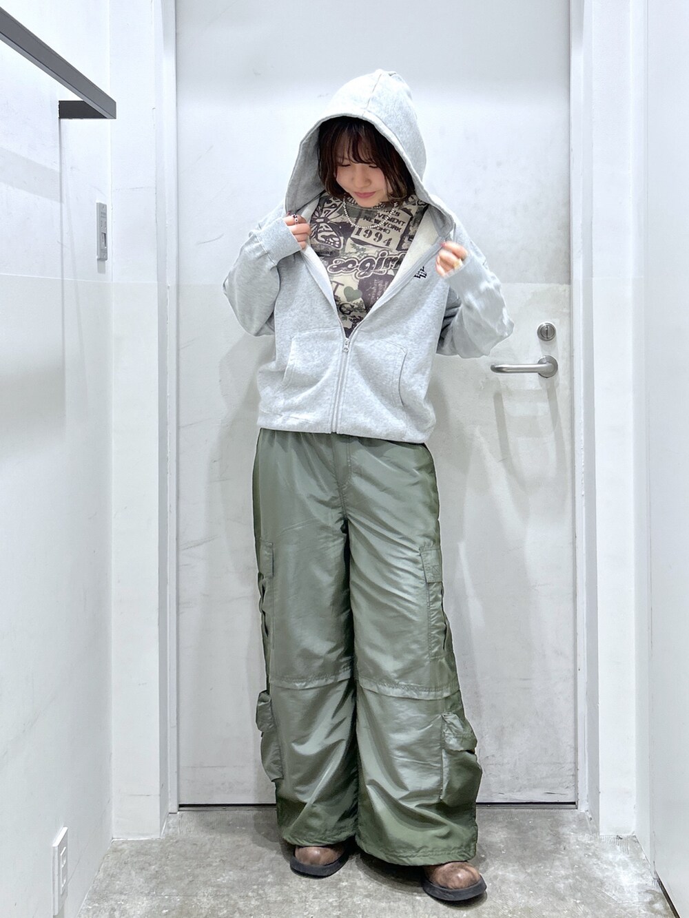グレー系のパーカー、グリーン系のカーゴパンツを着用したレディースの秋コーディネートの2枚目の写真