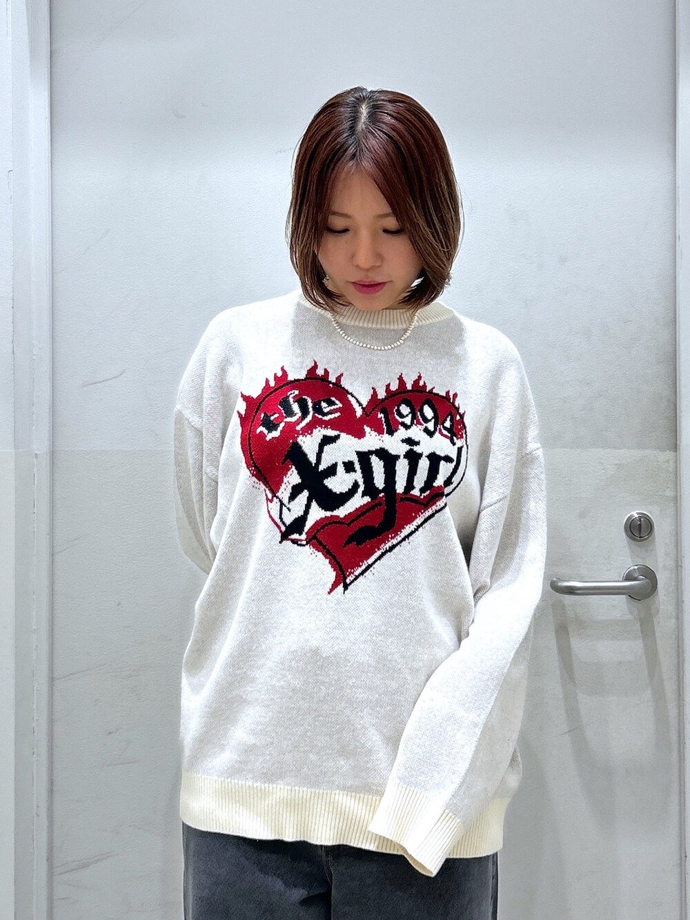 ホワイト系のニット/セーター、ブルー系のデニムパンツを着用したレディースの秋コーディネートの2枚目の写真