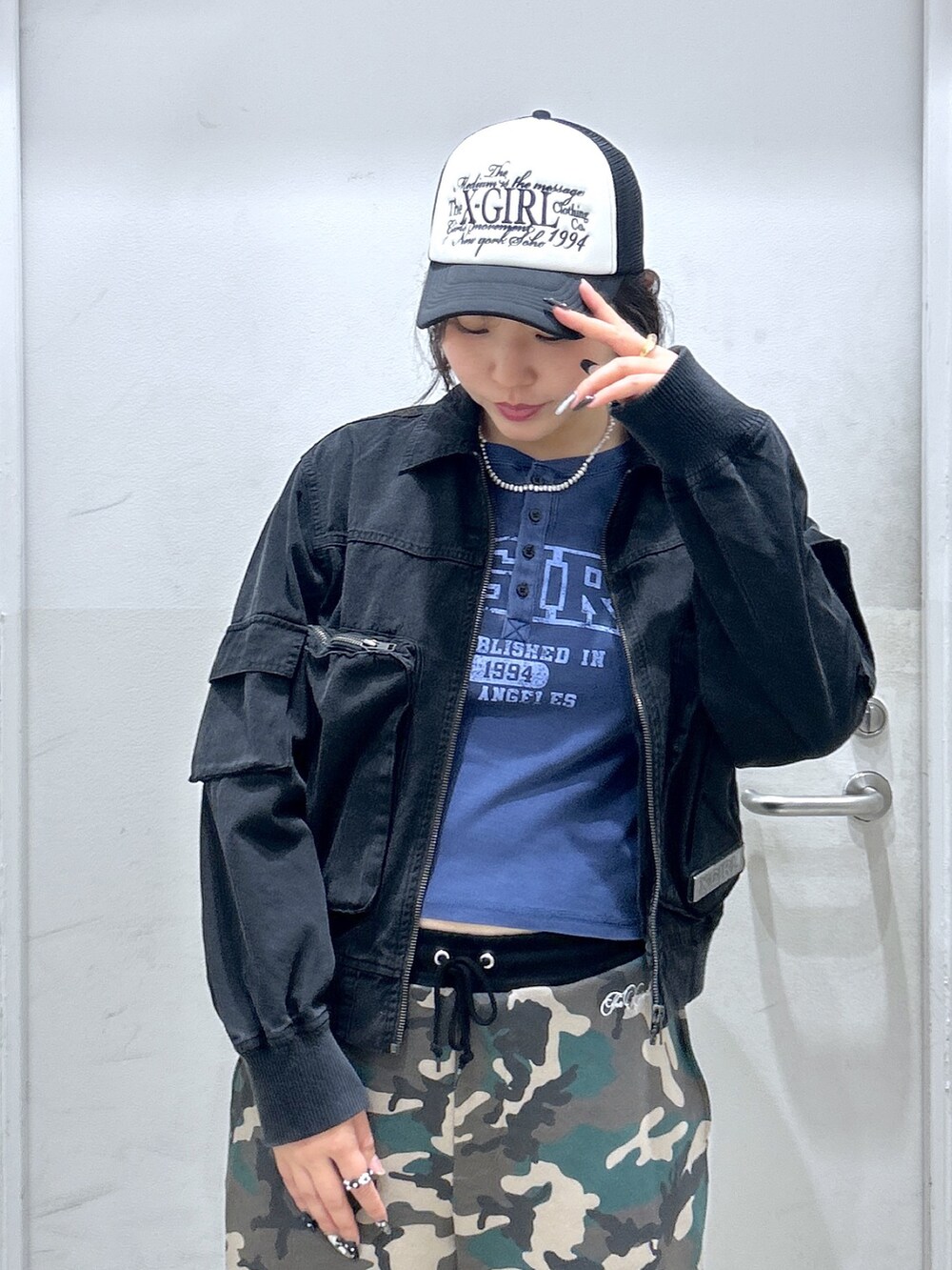 グリーン系のブルゾン、ブラック系のスウェットパンツ、ブルー系のTシャツ/カットソーを着用したレディースの秋コーディネートの2枚目の写真