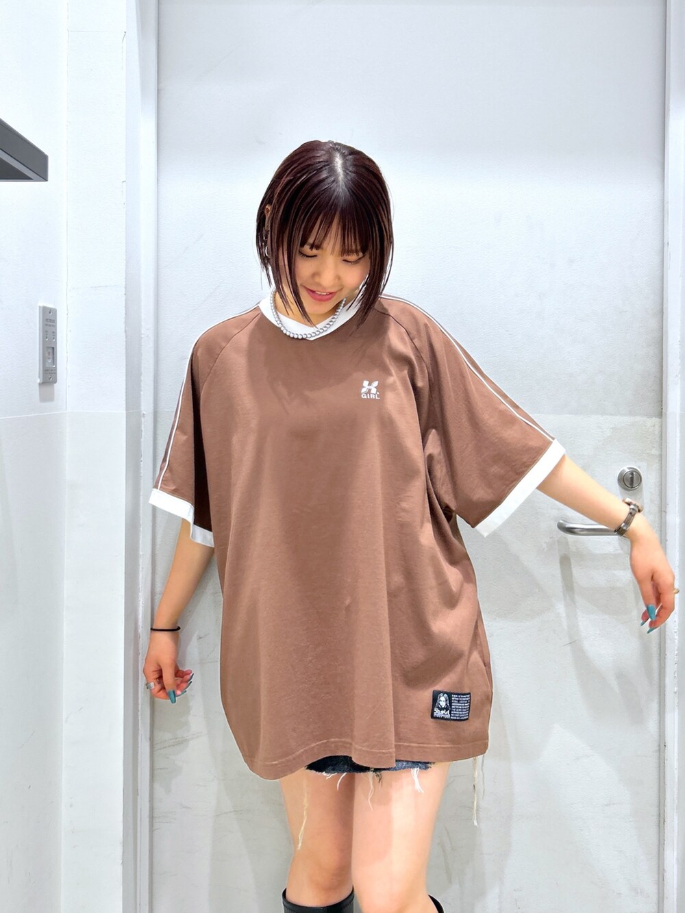 ブラウン系のワンピース、ブラック系のハンドバッグを着用したレディースの春コーディネートの2枚目の写真