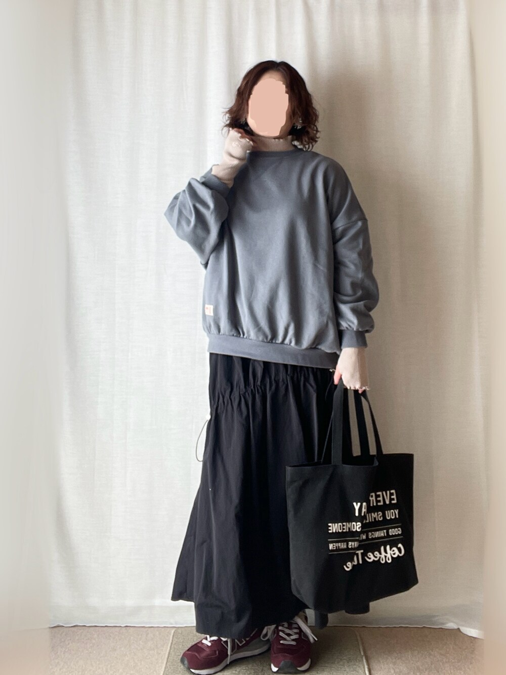 ブルー系のスウェット、ベージュ系のニット/セーター、ブラック系のスカートを着用したレディースの春コーディネートの2枚目の写真