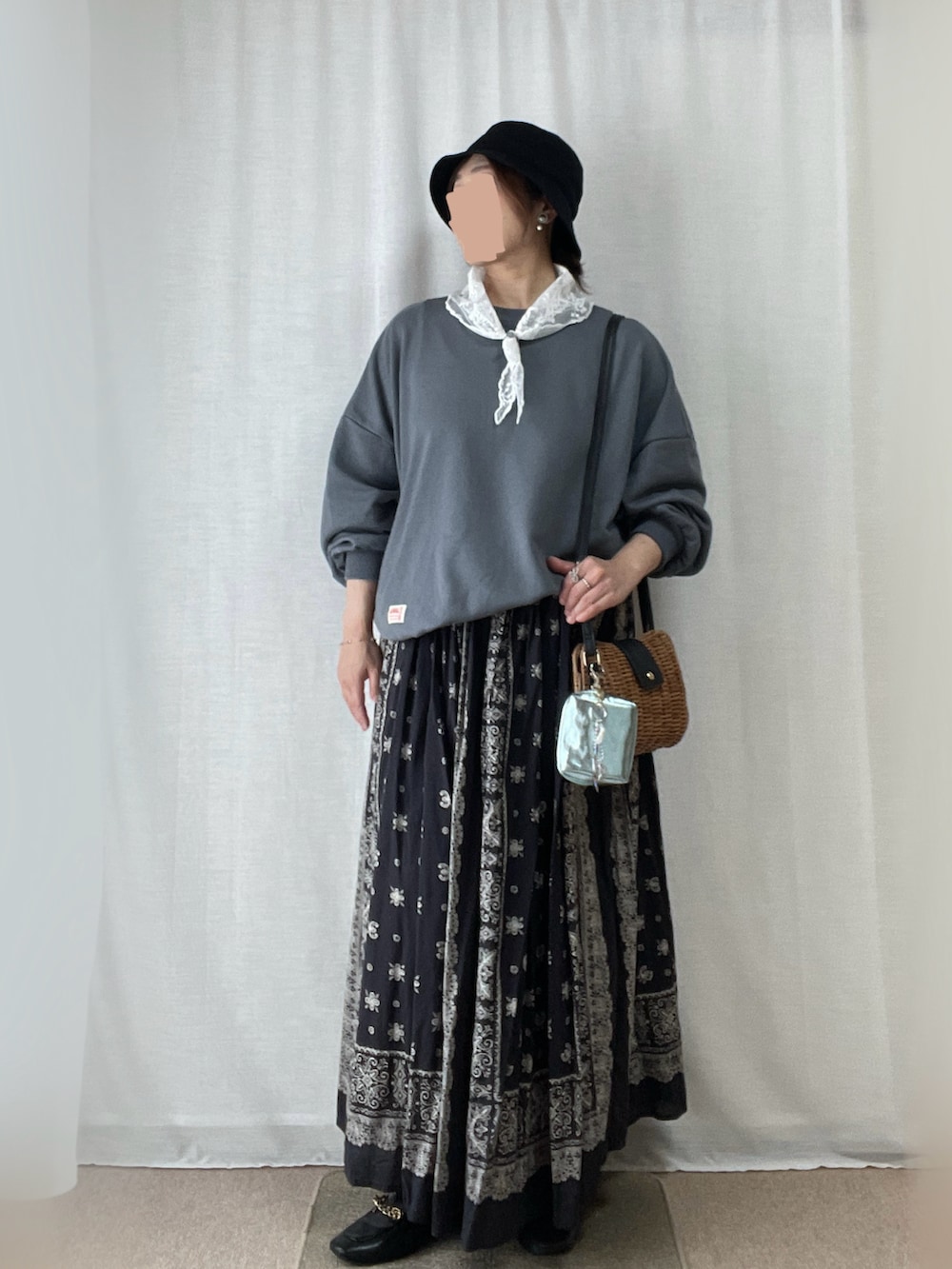 グレー系のスカート、ブルー系のスウェット、ブラウン系のショルダーバッグを着用したレディースの春コーディネートの2枚目の写真