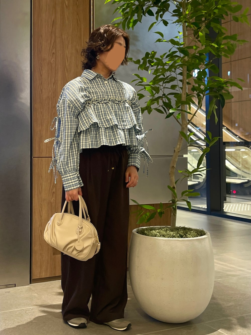 ブルー系のシャツ/ブラウス、ブラウン系のパンツ、その他のボストンバッグを着用したレディースの春コーディネートの2枚目の写真
