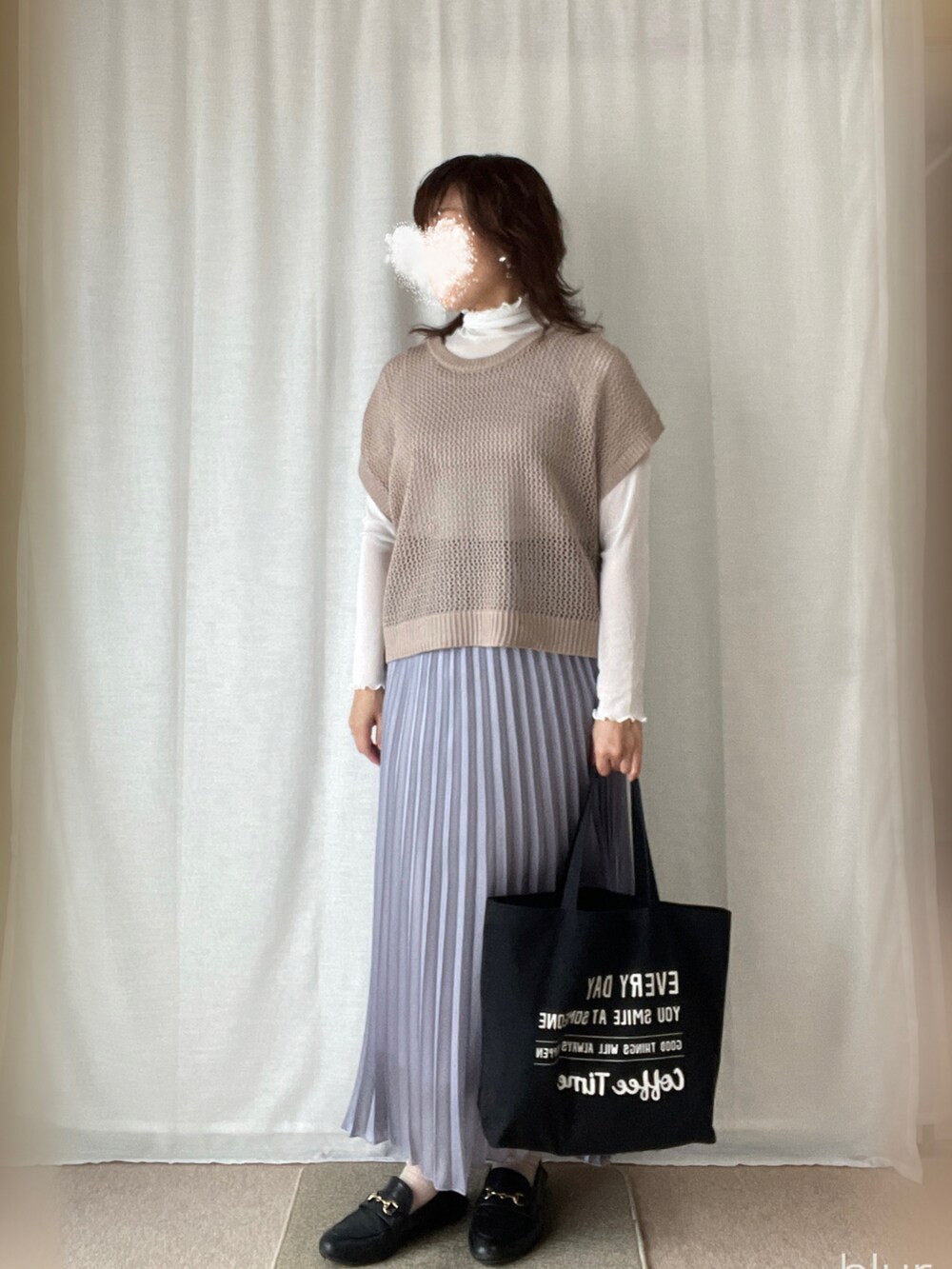 ベージュ系のベスト、パープル系のスカートを着用したレディースの春コーディネートの2枚目の写真