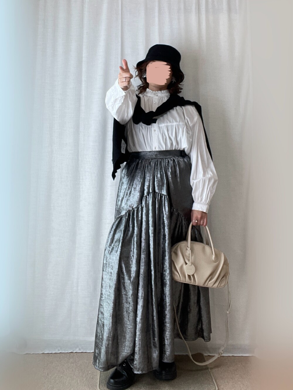 ホワイト系のチュニック、シルバー系のスカート、ブラック系のローファーを着用したレディースの春コーディネートの2枚目の写真