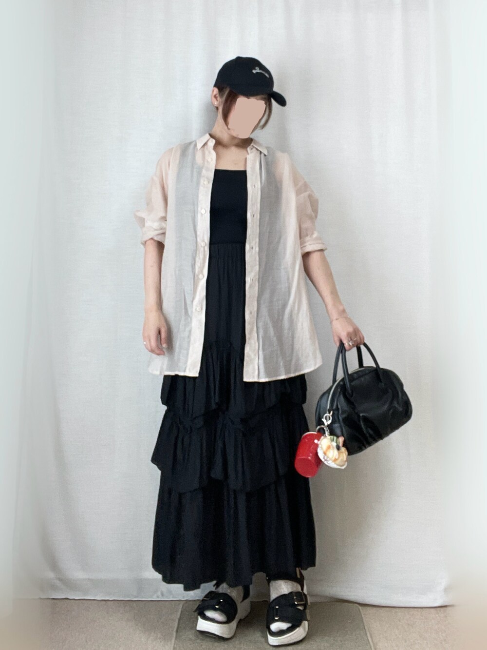 ブラック系のスカート、ブラック系のタンクトップ、ベージュ系のシャツ/ブラウスを着用したレディースの春コーディネートの2枚目の写真