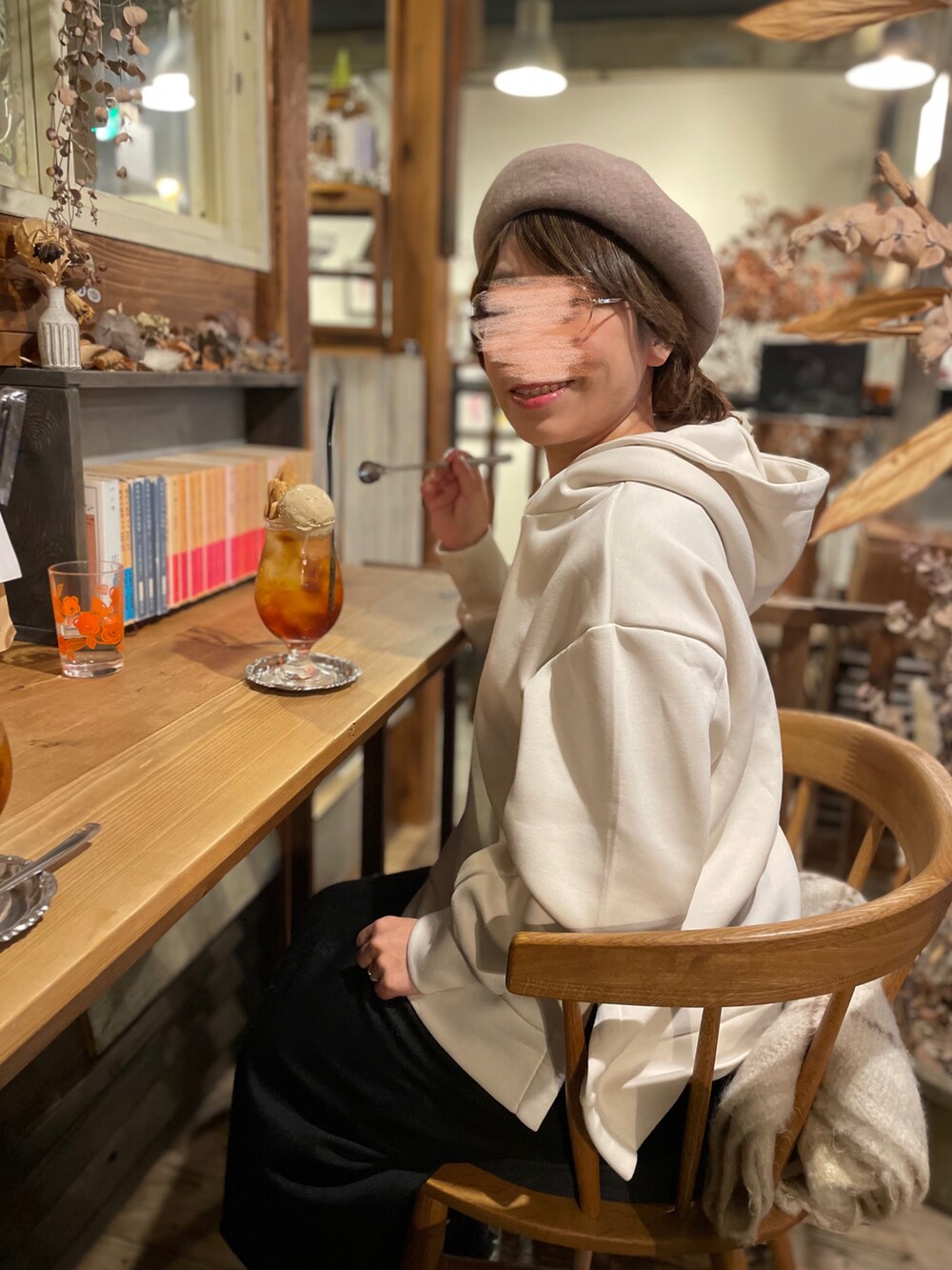 ホワイト系のパーカー、ブラック系のスカート、ブラック系のスニーカーを着用したレディースの秋コーディネートの3枚目の写真