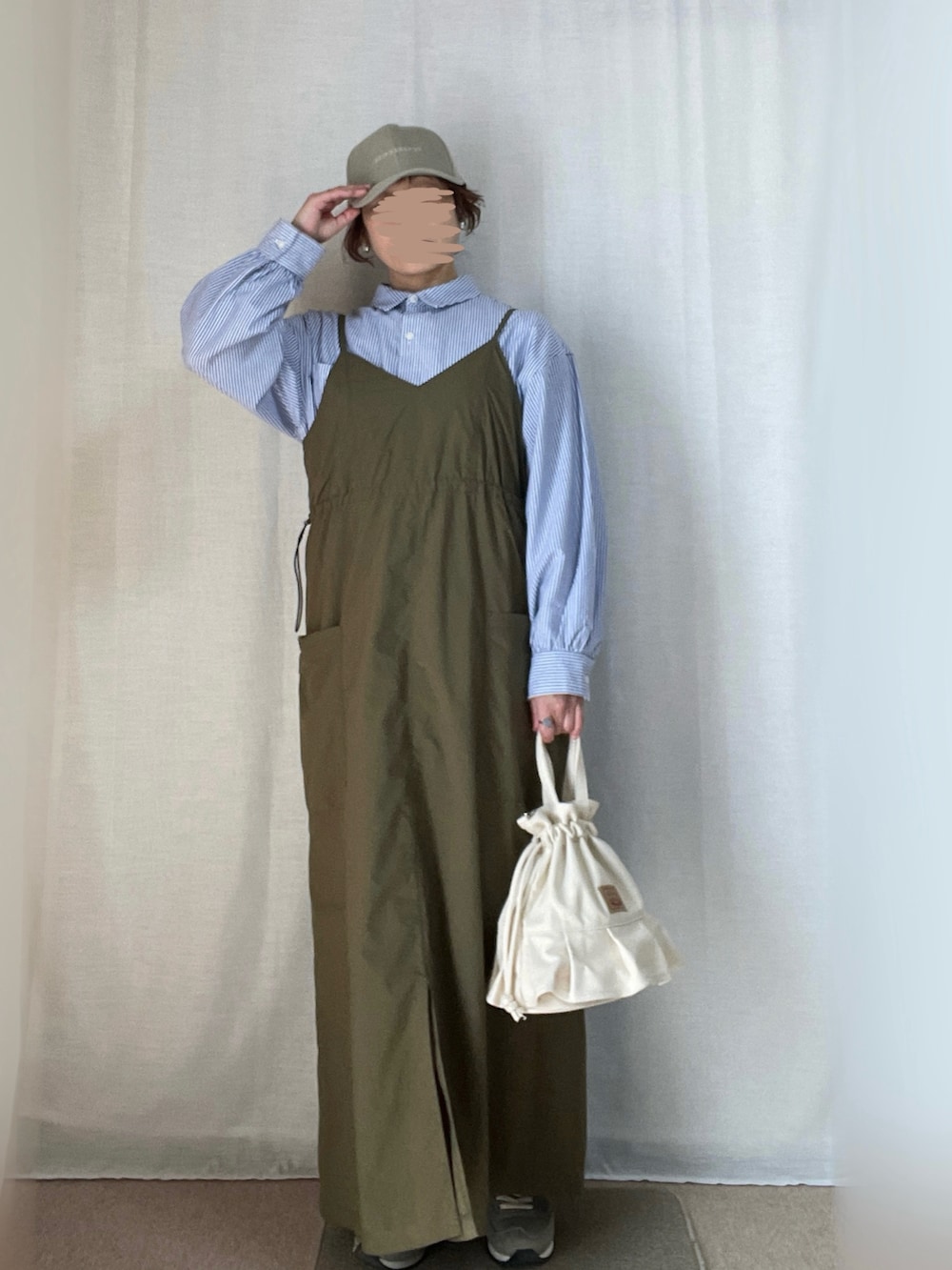 グリーン系のワンピース、ブルー系のシャツ/ブラウス、グリーン系のスニーカーを着用したレディースの春コーディネートの2枚目の写真