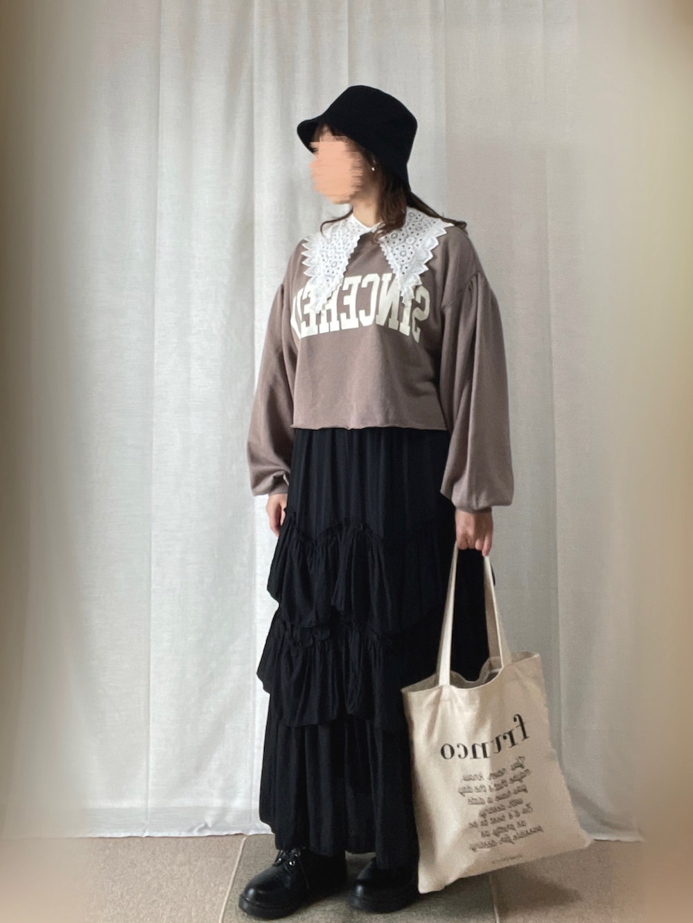 ベージュ系のTシャツ/カットソー、ブラック系のスカート、ブラック系のローファーを着用したレディースの冬コーディネートの2枚目の写真