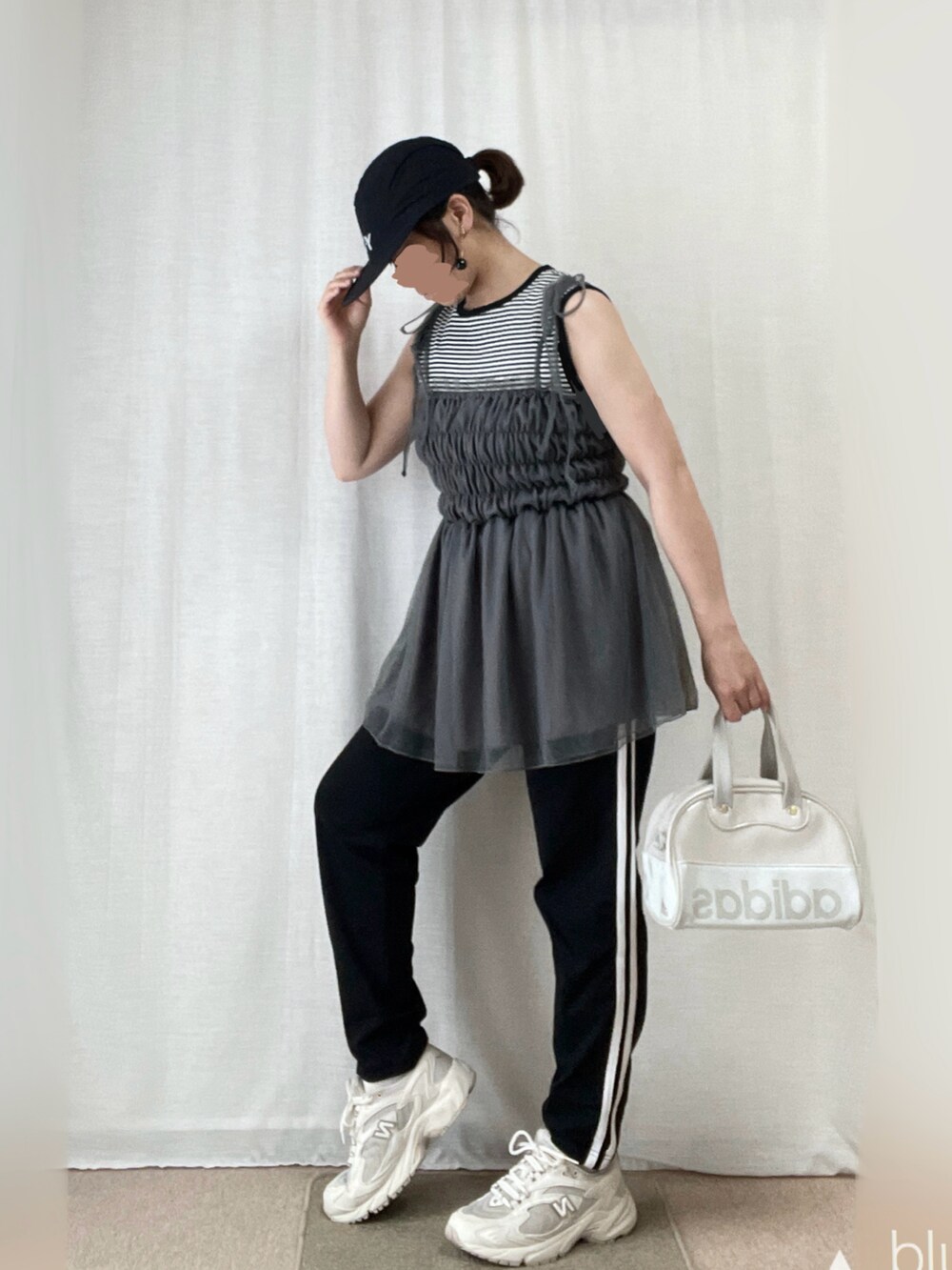 グレー系のキャミソール、ホワイト系のスニーカー、グレー系のバッグを着用したレディースの夏コーディネートの2枚目の写真