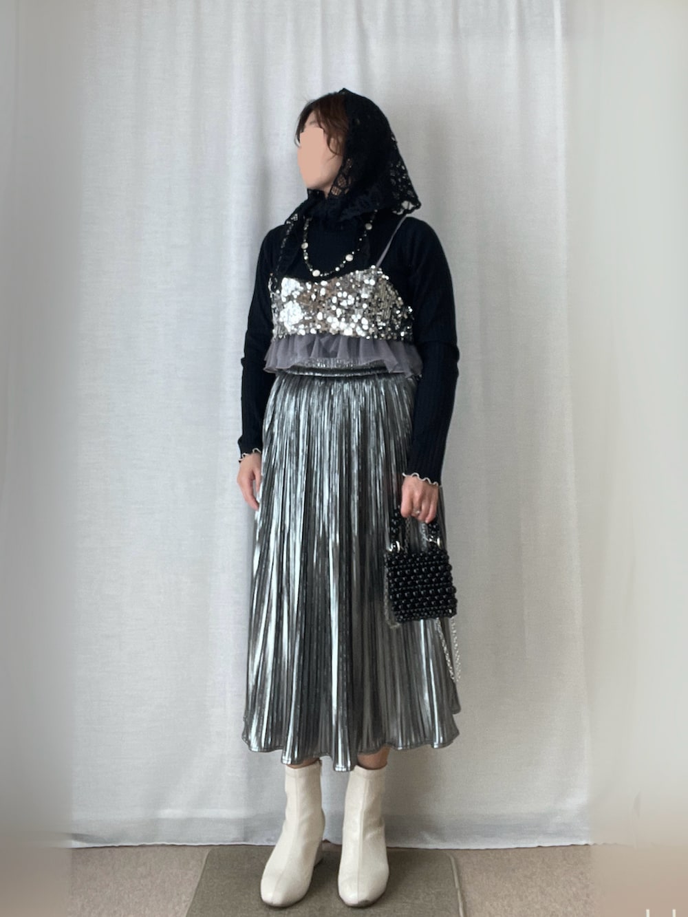 シルバー系のキャミソール、シルバー系のスカート、ブラック系のTシャツ/カットソーを着用したレディースの春コーディネートの2枚目の写真