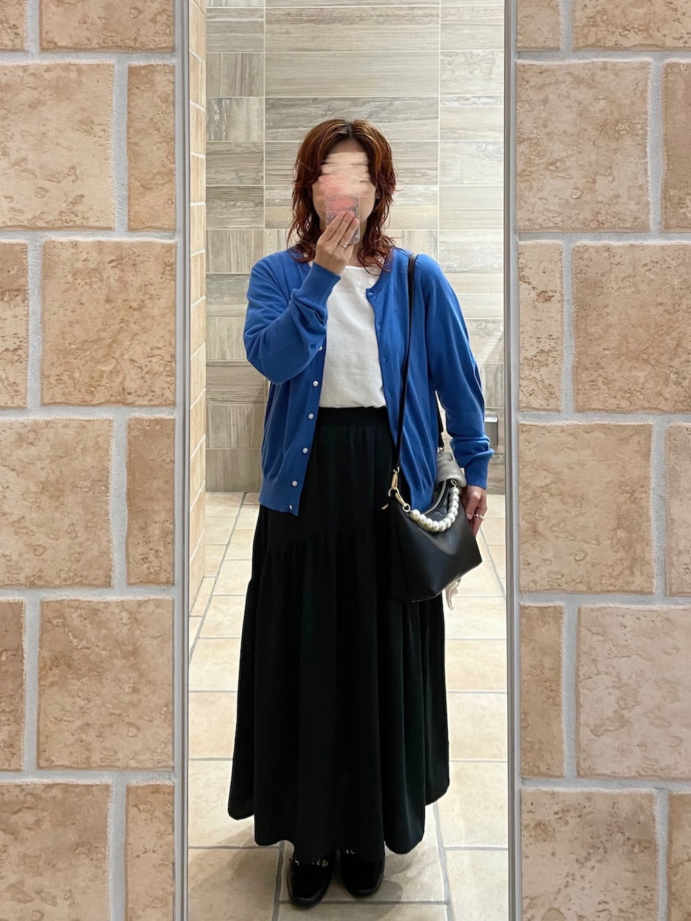 ホワイト系のシャツ/ブラウス、ブルー系のカーディガン/ボレロ、ブラック系のローファーを着用したレディースの秋コーディネートの2枚目の写真