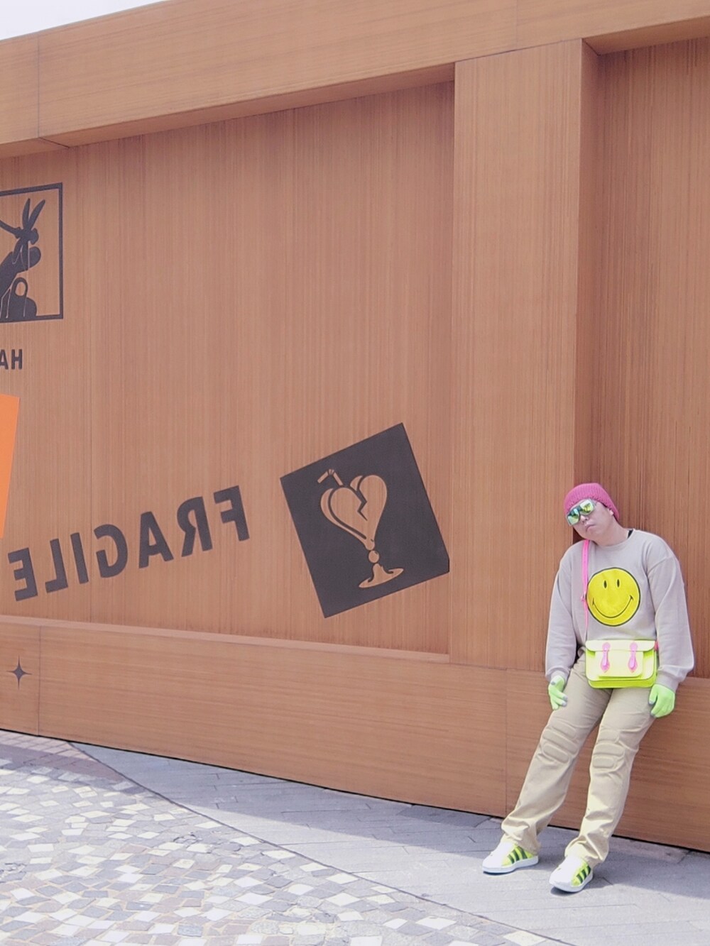 イエロー系のスニーカー、ベージュ系のチノパンツ、イエロー系のバッグを着用したメンズの春コーディネートの3枚目の写真
