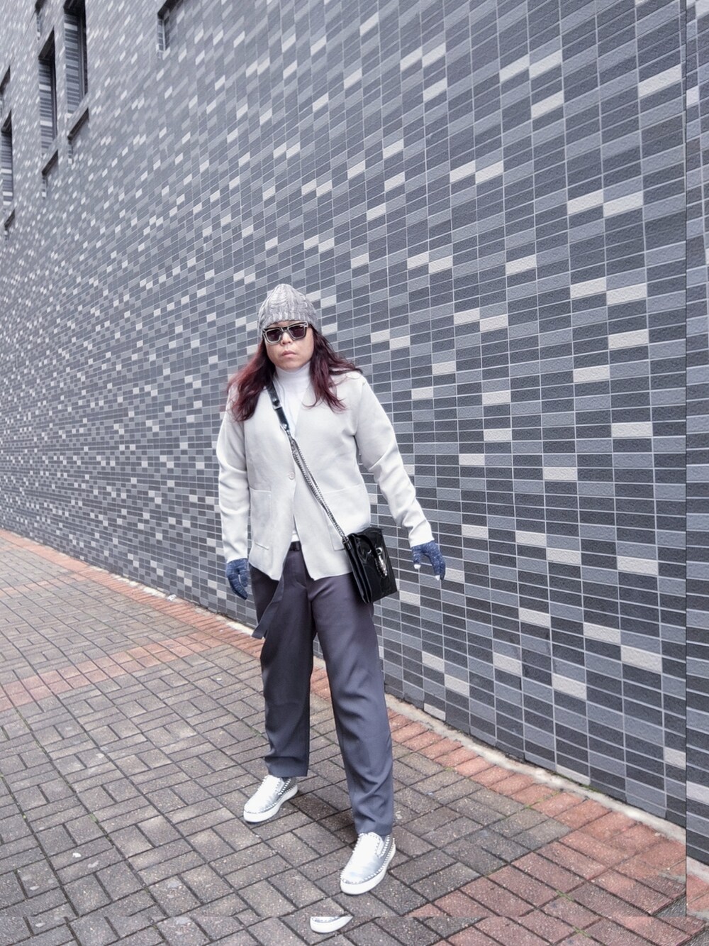 グレー系のスラックス、シルバー系のモカシン/デッキシューズ、グレー系のノーカラージャケットを着用したメンズの冬コーディネートの2枚目の写真