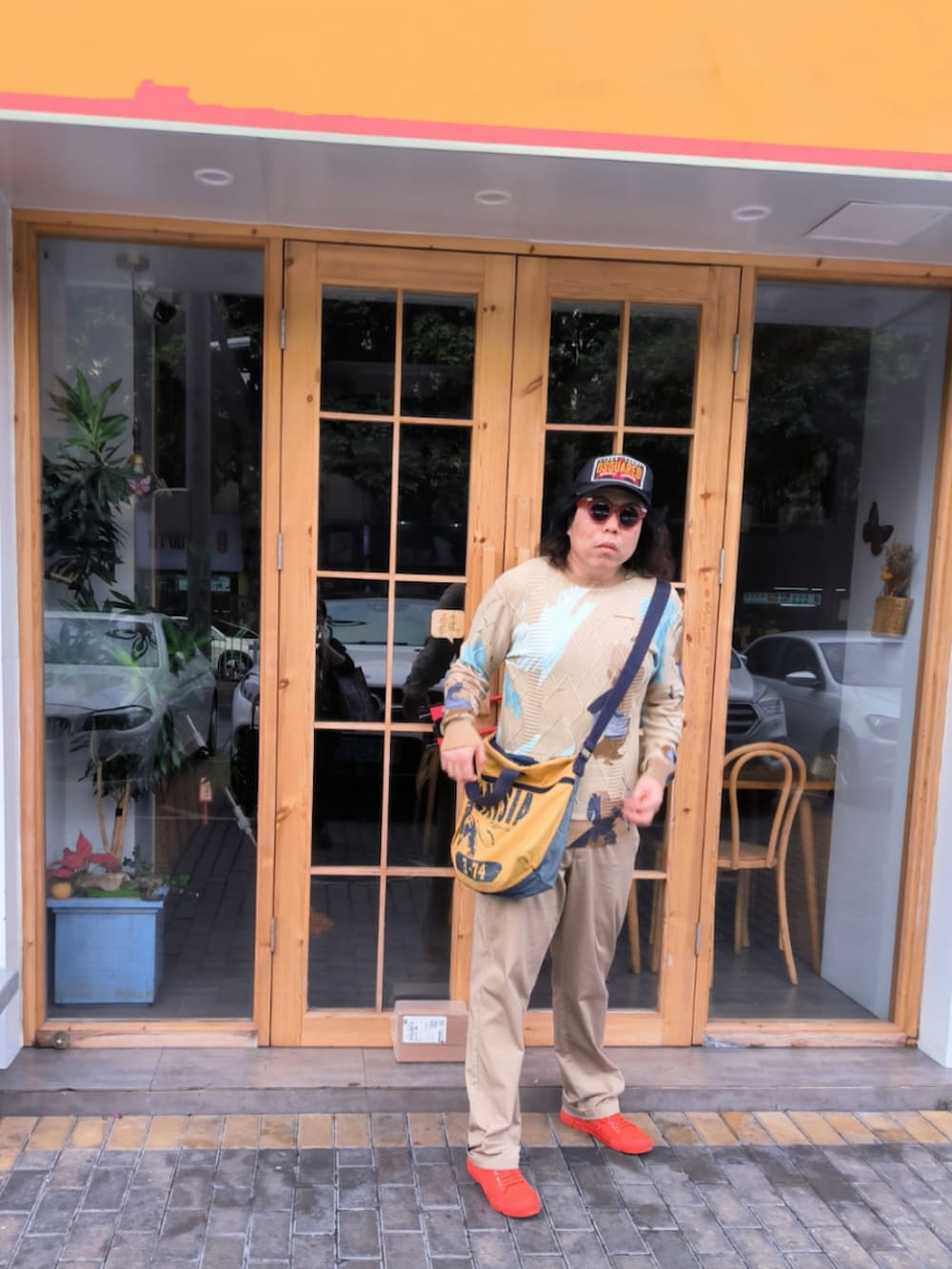 ベージュ系のパンツ、オレンジ系のシューズ、ベージュ系のニット/セーターを着用したメンズの冬コーディネートの2枚目の写真