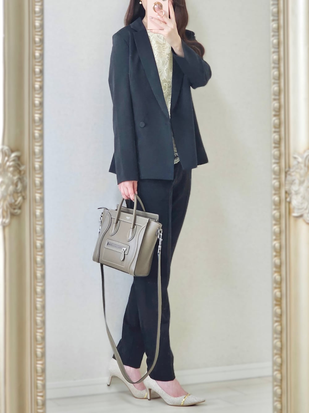 ブラック系のスーツセット、ベージュ系のバッグ、ベージュ系のパンプスを着用したレディースの夏コーディネートの3枚目の写真