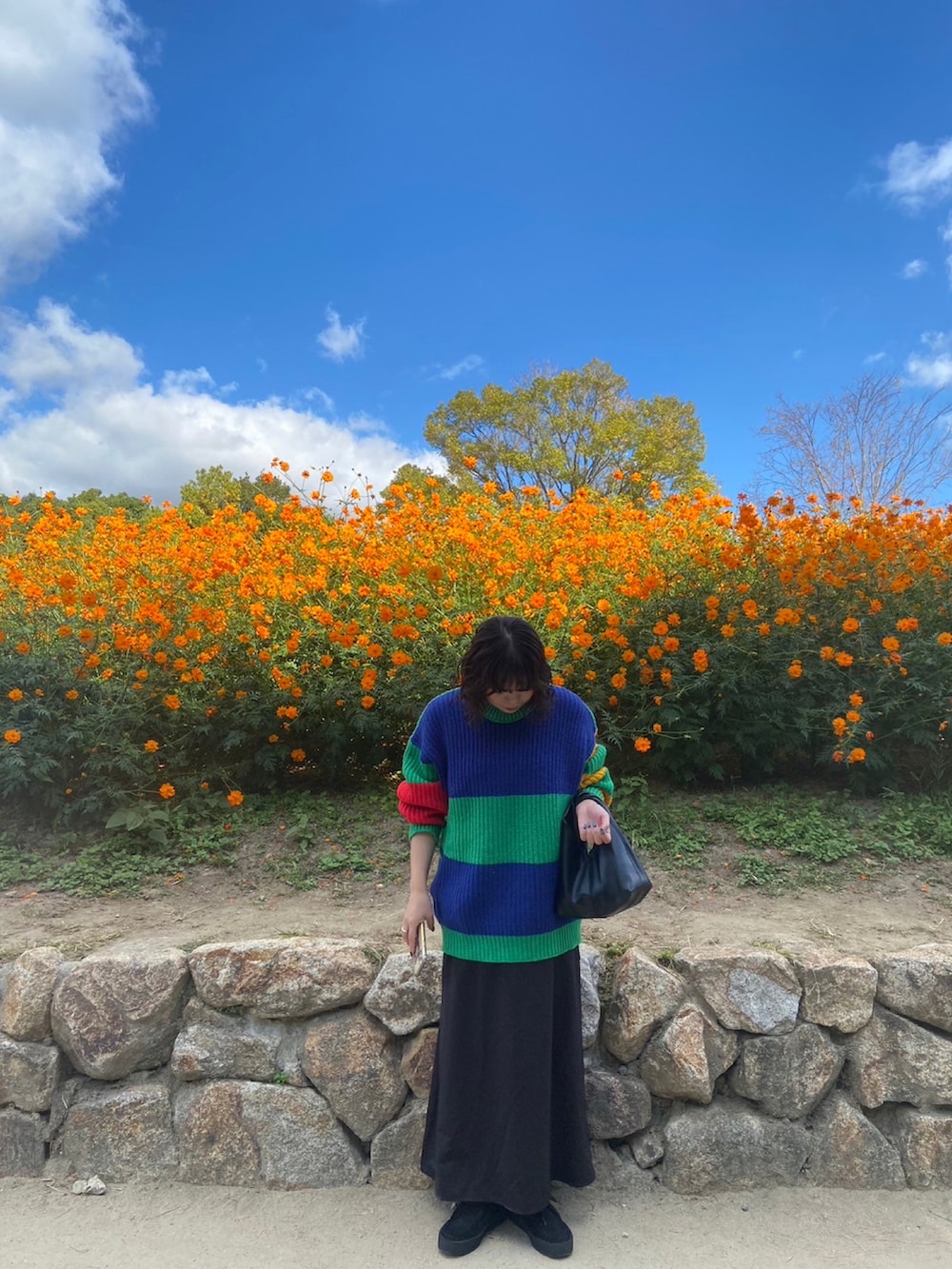 ブラック系のモカシン/デッキシューズ、ブラック系のワンピース、ブラック系のバッグを着用したレディースの秋コーディネートの2枚目の写真