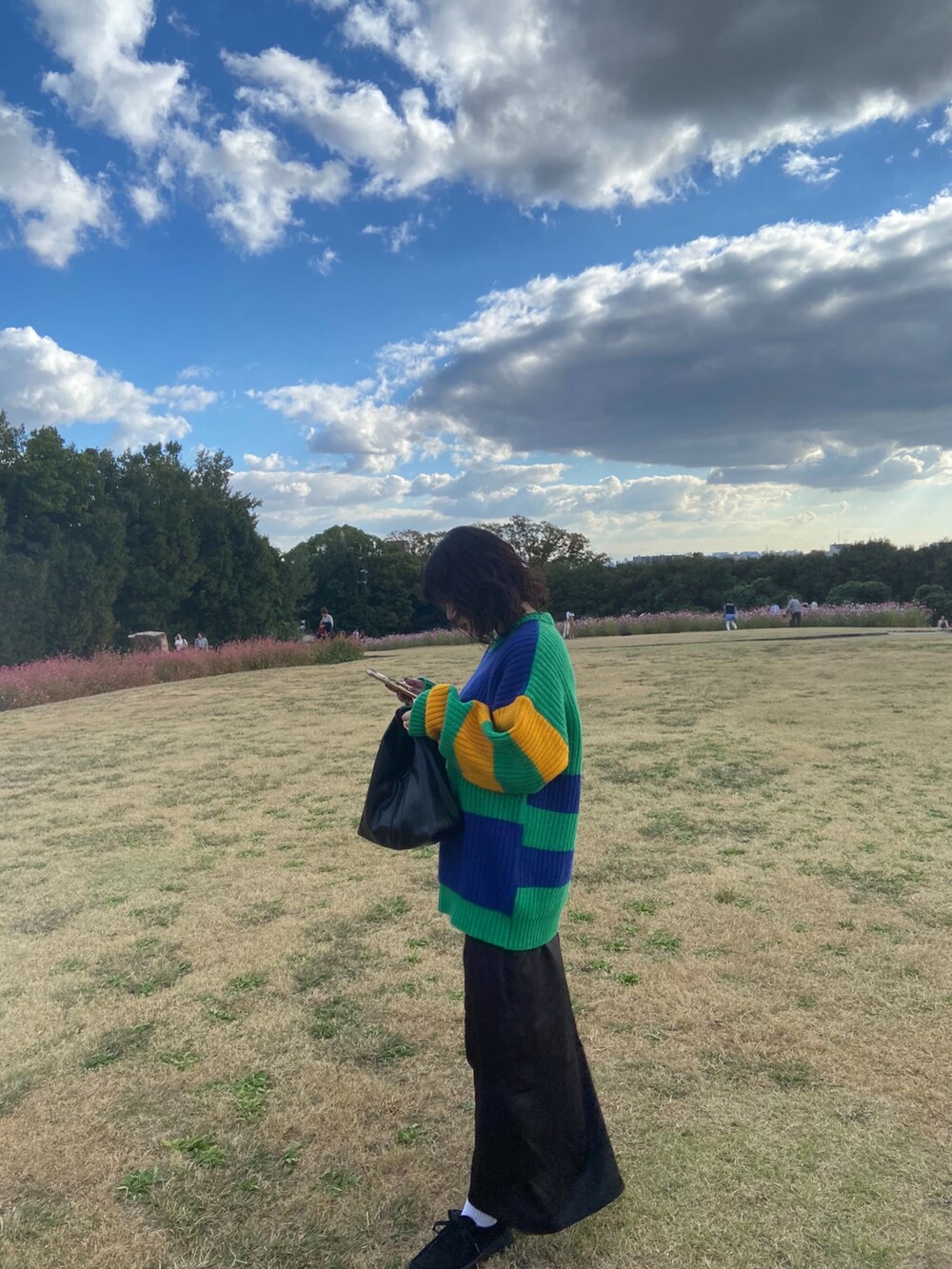 ブラック系のモカシン/デッキシューズ、ブラック系のワンピース、ブラック系のバッグを着用したレディースの秋コーディネートの4枚目の写真