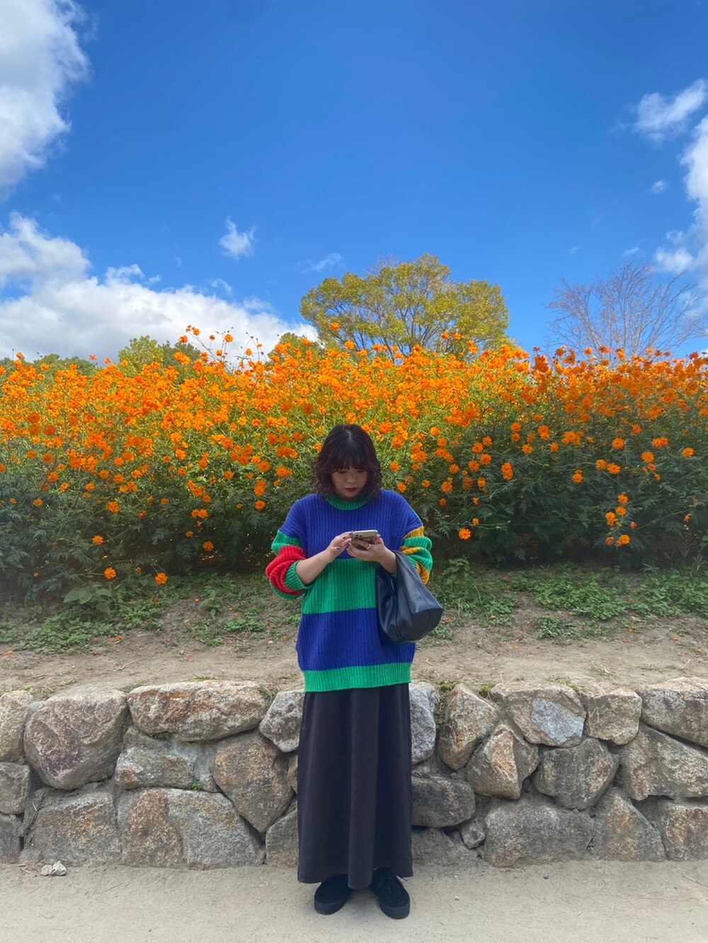 ブラック系のモカシン/デッキシューズ、ブラック系のワンピース、ブラック系のバッグを着用したレディースの秋コーディネートの3枚目の写真