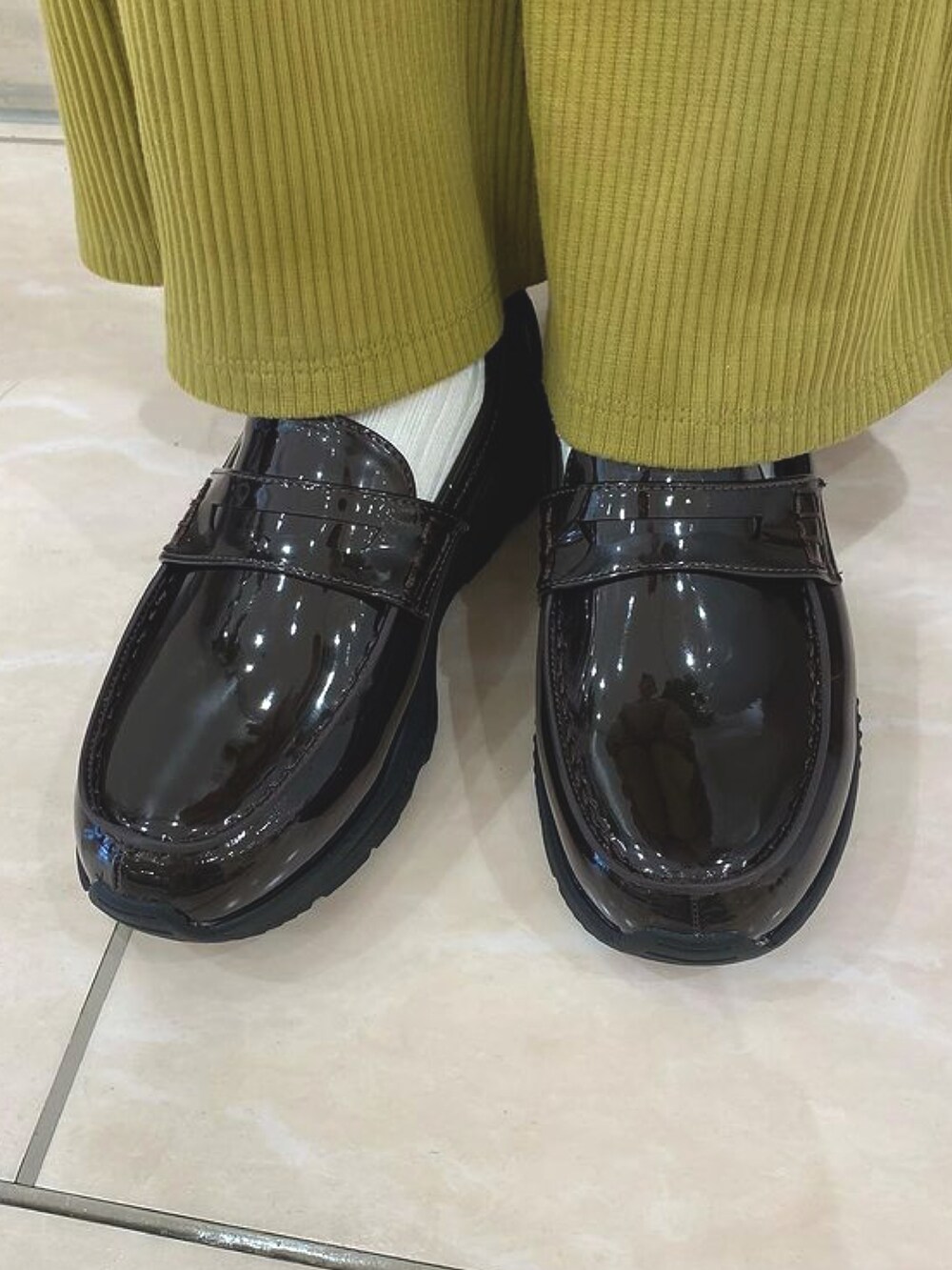 ブラウン系のローファーを着用したレディースの秋コーディネートの2枚目の写真