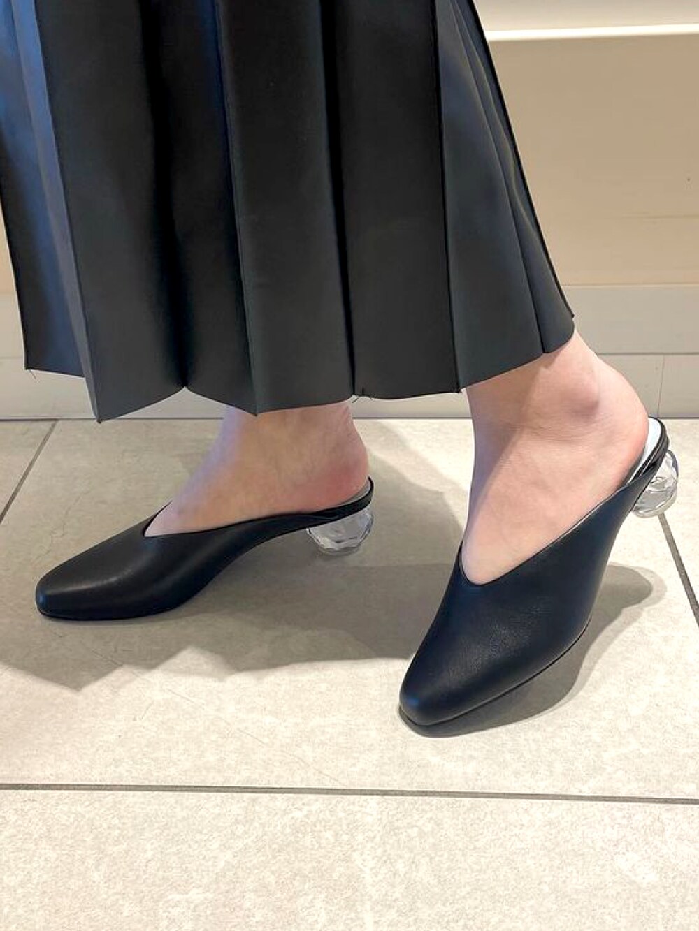 ブラック系のサンダルを着用したレディースの春コーディネートの2枚目の写真