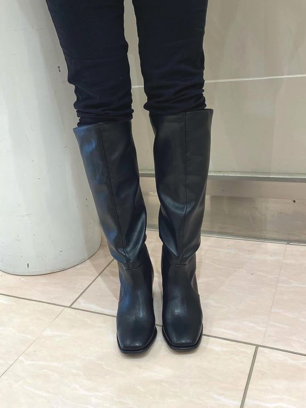 ブラック系のブーツを着用したレディースの秋コーディネートの2枚目の写真