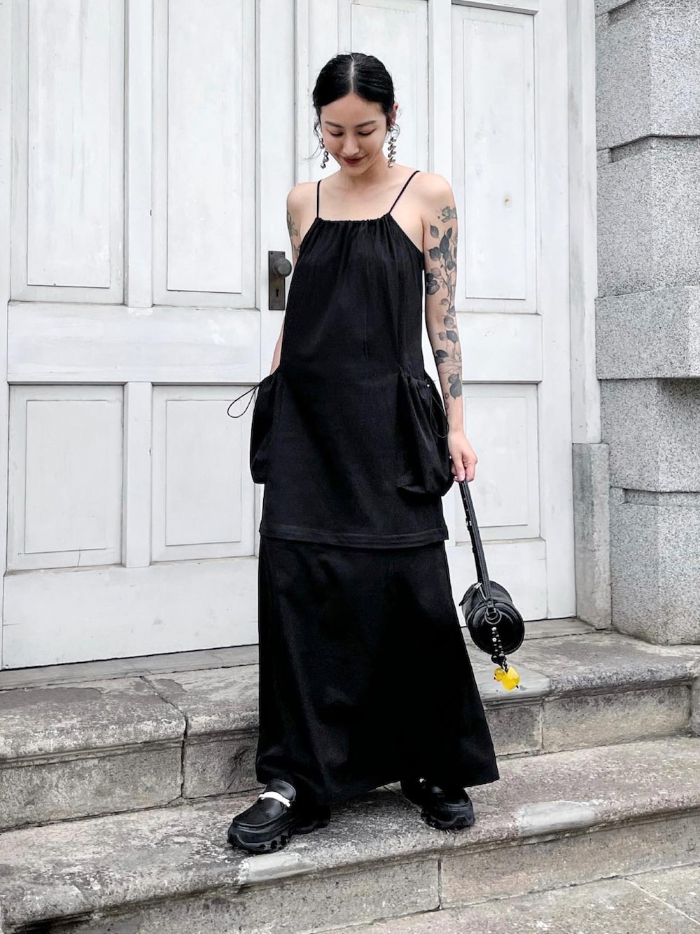 ブラック系のスニーカー、ブラック系のショルダーバッグを着用したレディースの春コーディネートの2枚目の写真