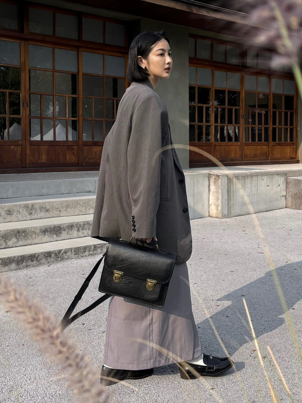 ブラック系のローファーを着用したレディースの春コーディネートの2枚目の写真