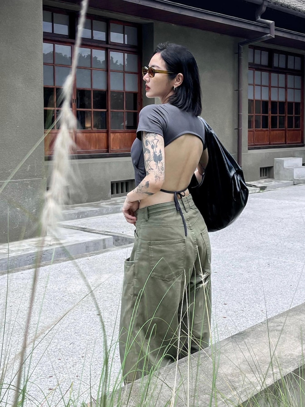 グリーン系のチノパンツを着用したレディースの夏コーディネートの2枚目の写真